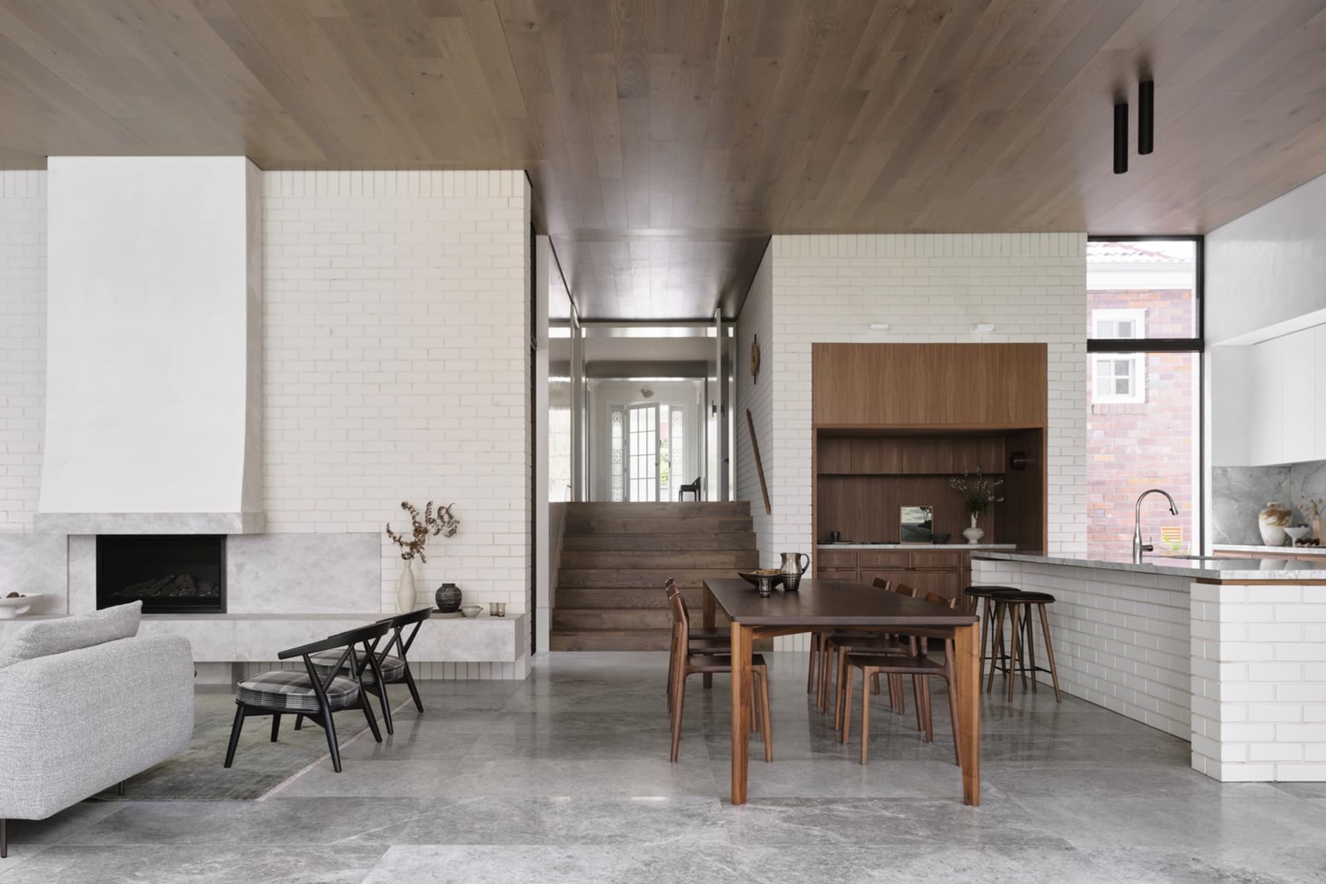 Modern residential kitchen featuring concrete, brick, and wood materials with a minimalist design.