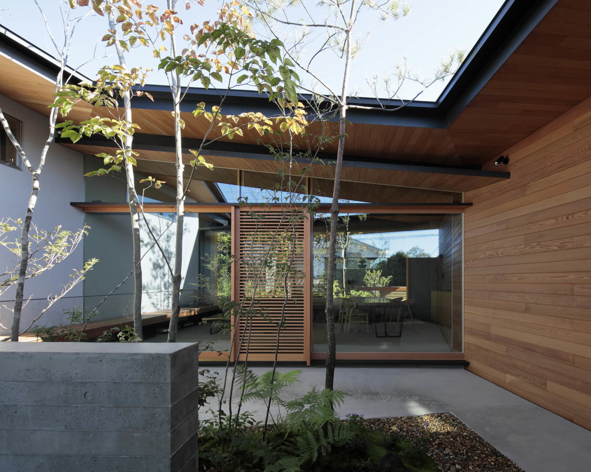 A modern exterior with wooden elements and a concrete planter.