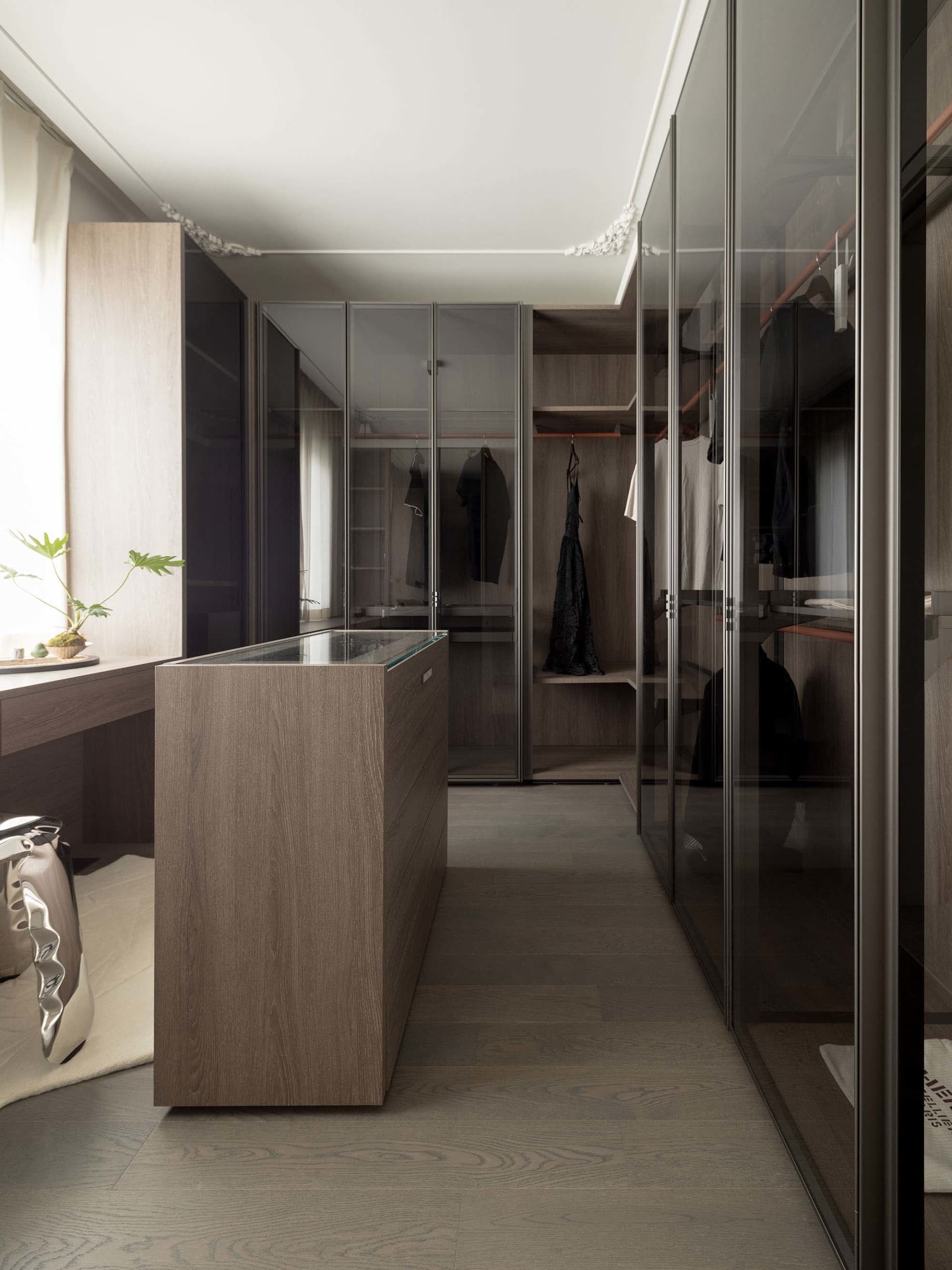Modern minimalist closet with glass and wood elements.