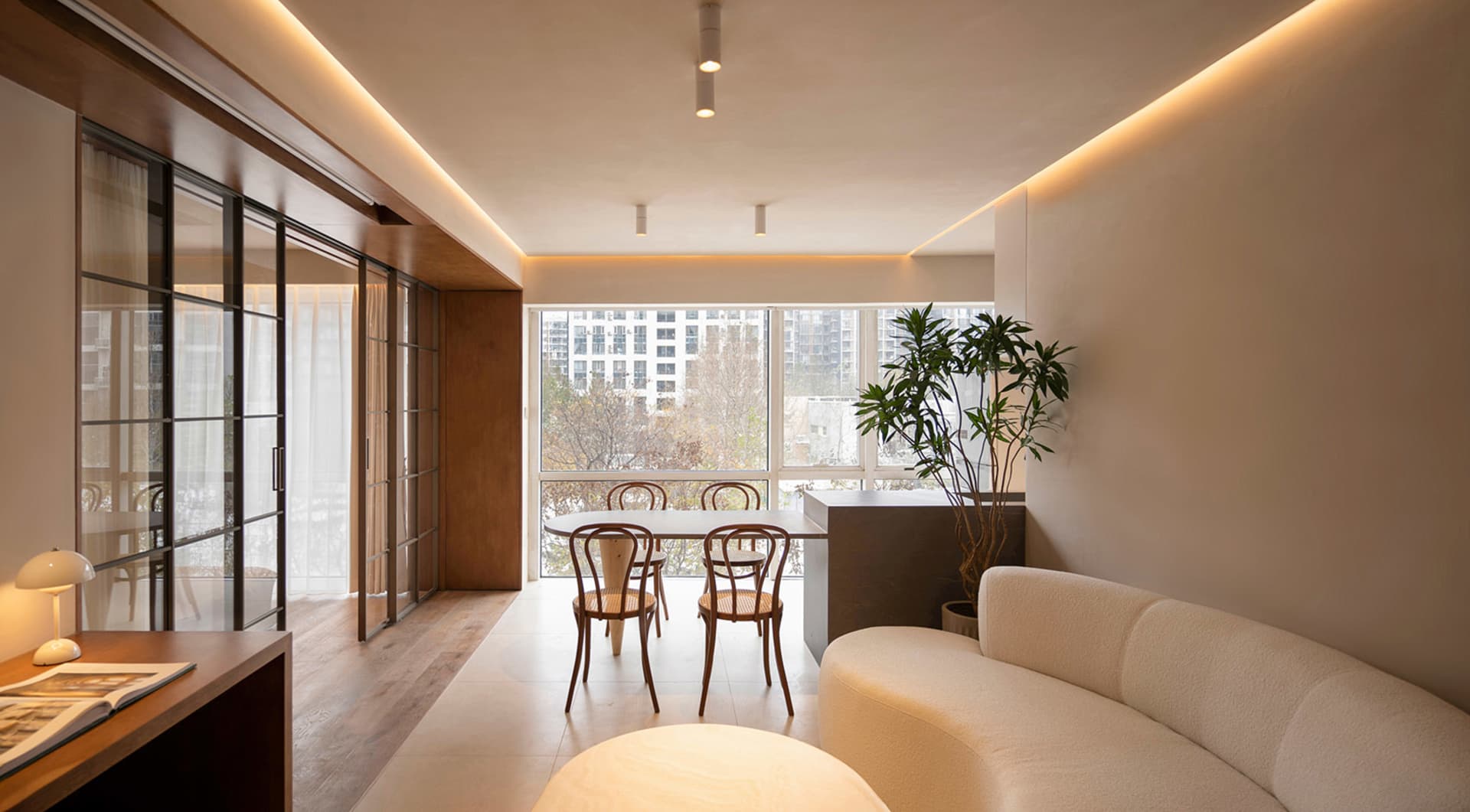 A modern living and dining room with neutral tones and minimalist design.