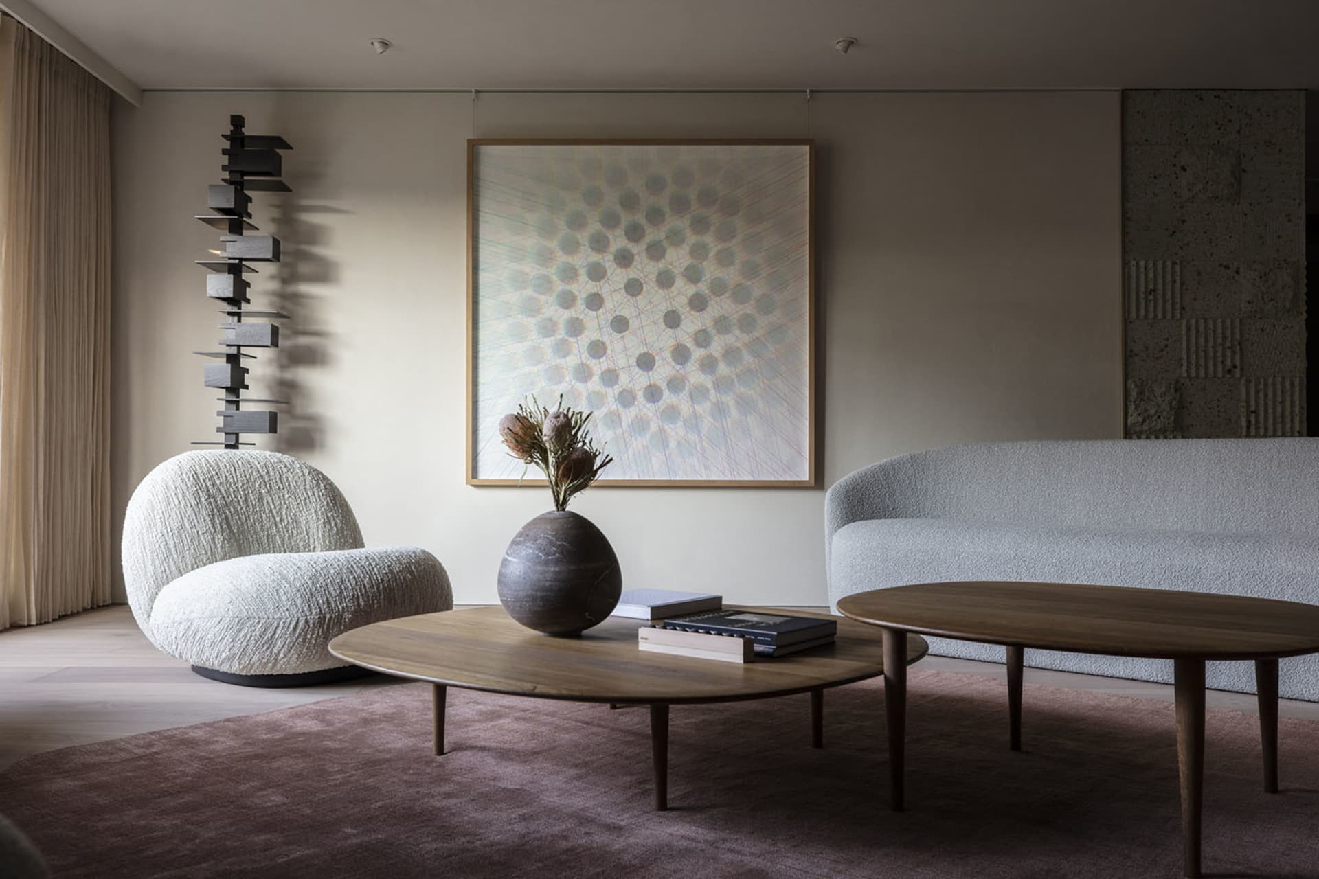A modern minimalist living room featuring a marble coffee table, wooden sofa, and plush fabric chairs.