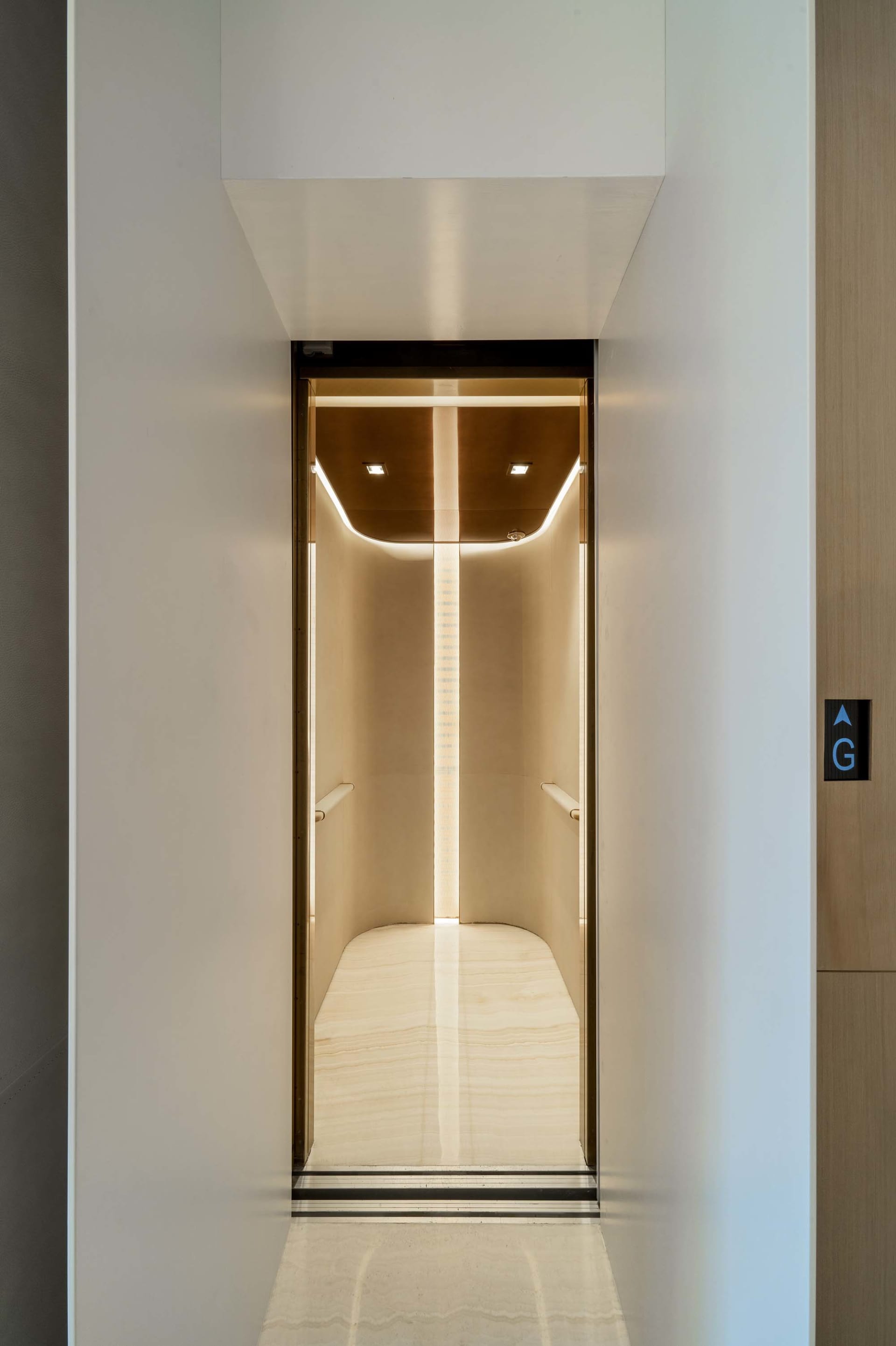 Modern, luxurious elevator interior with warm lighting and minimalist design.