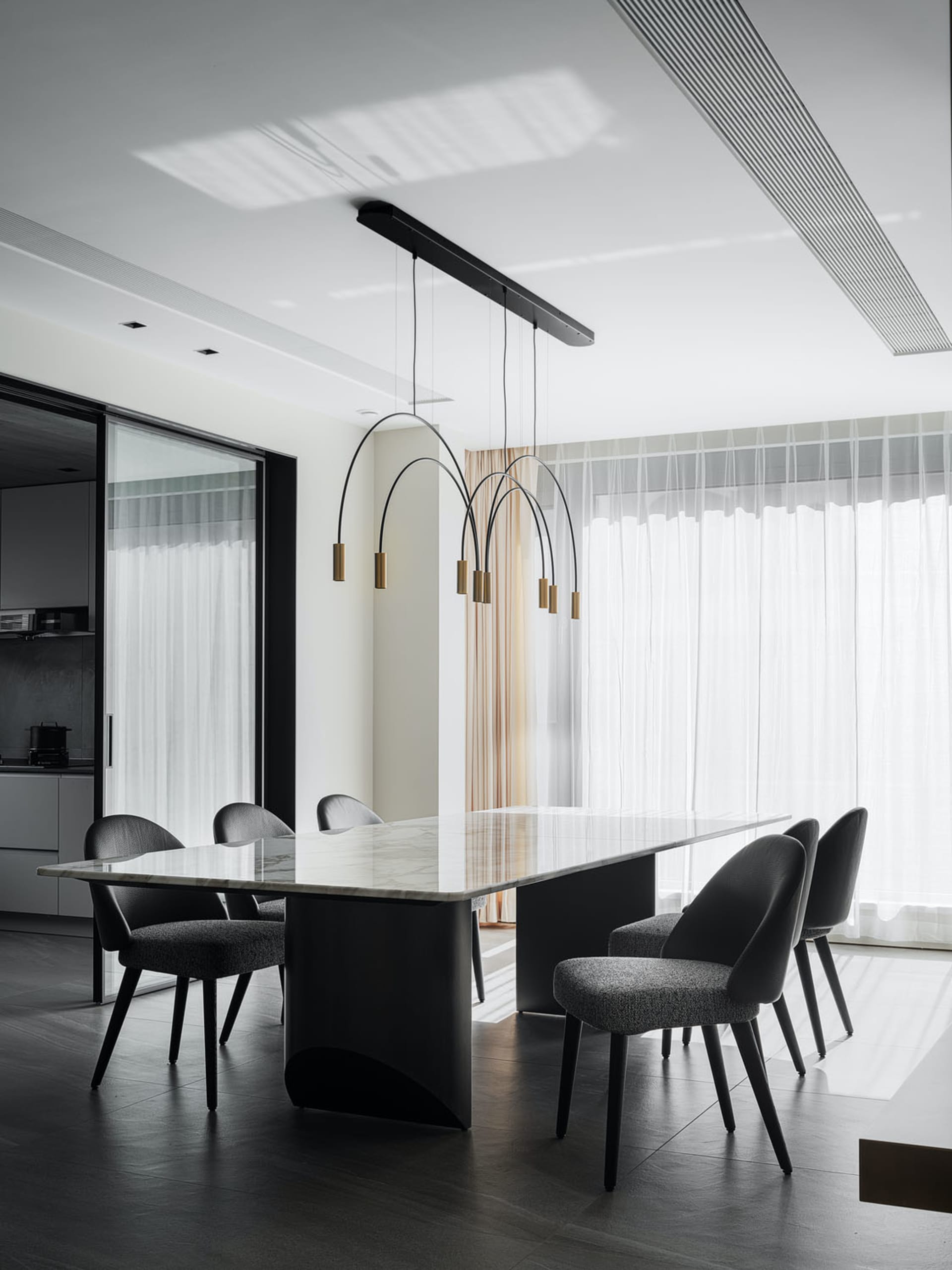 Modern dining room with marble table and black furniture.