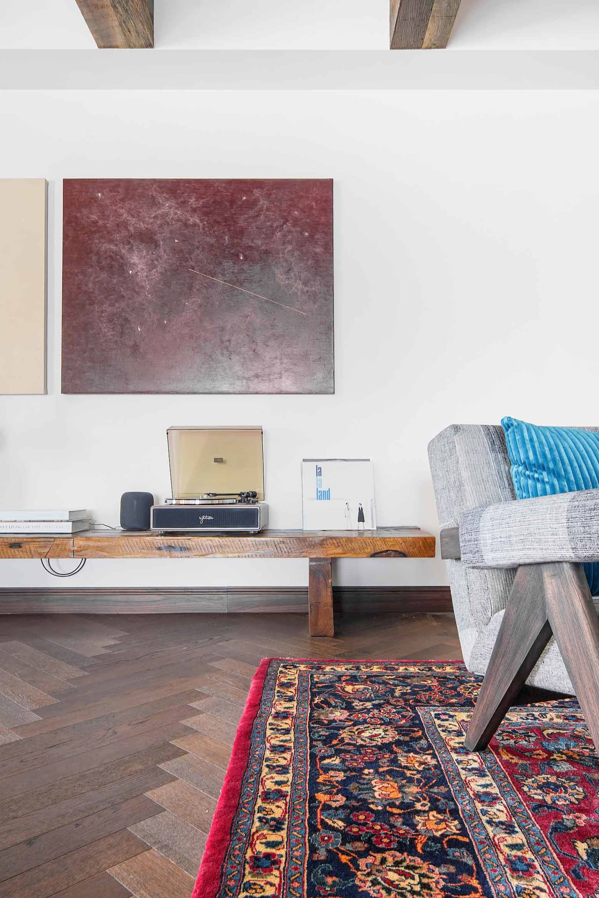 A modern living room featuring wooden furniture and a patterned rug.