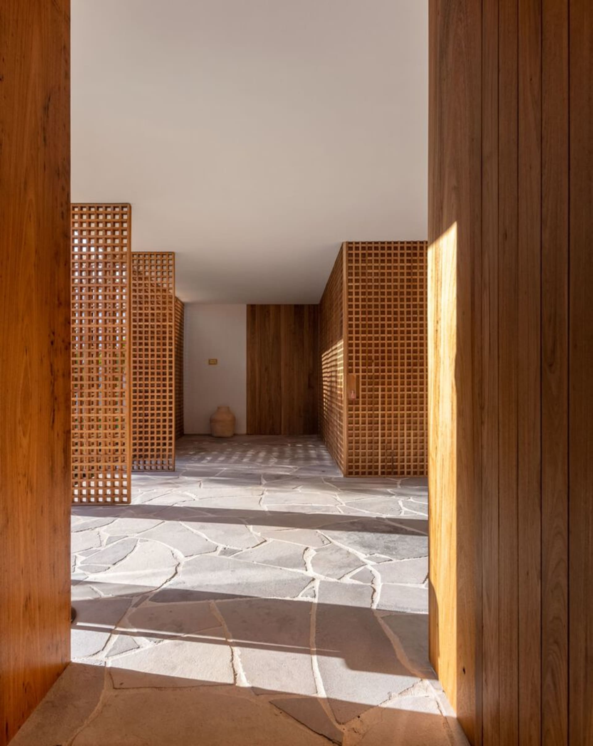 Modern interior design featuring a wooden floor with geometric patterns and natural light.