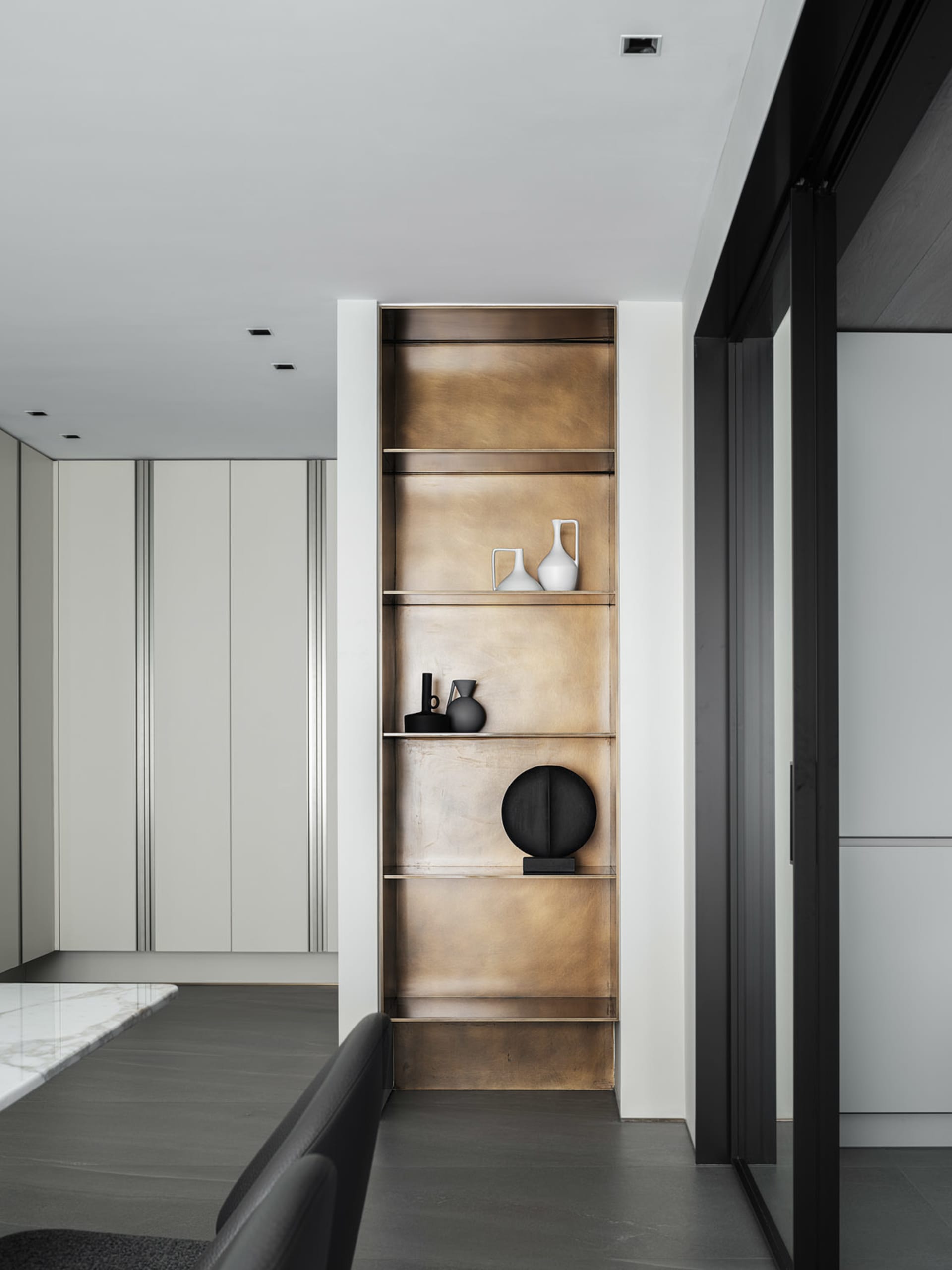Modern minimalist kitchen featuring metal shelves adorned with contemporary art.