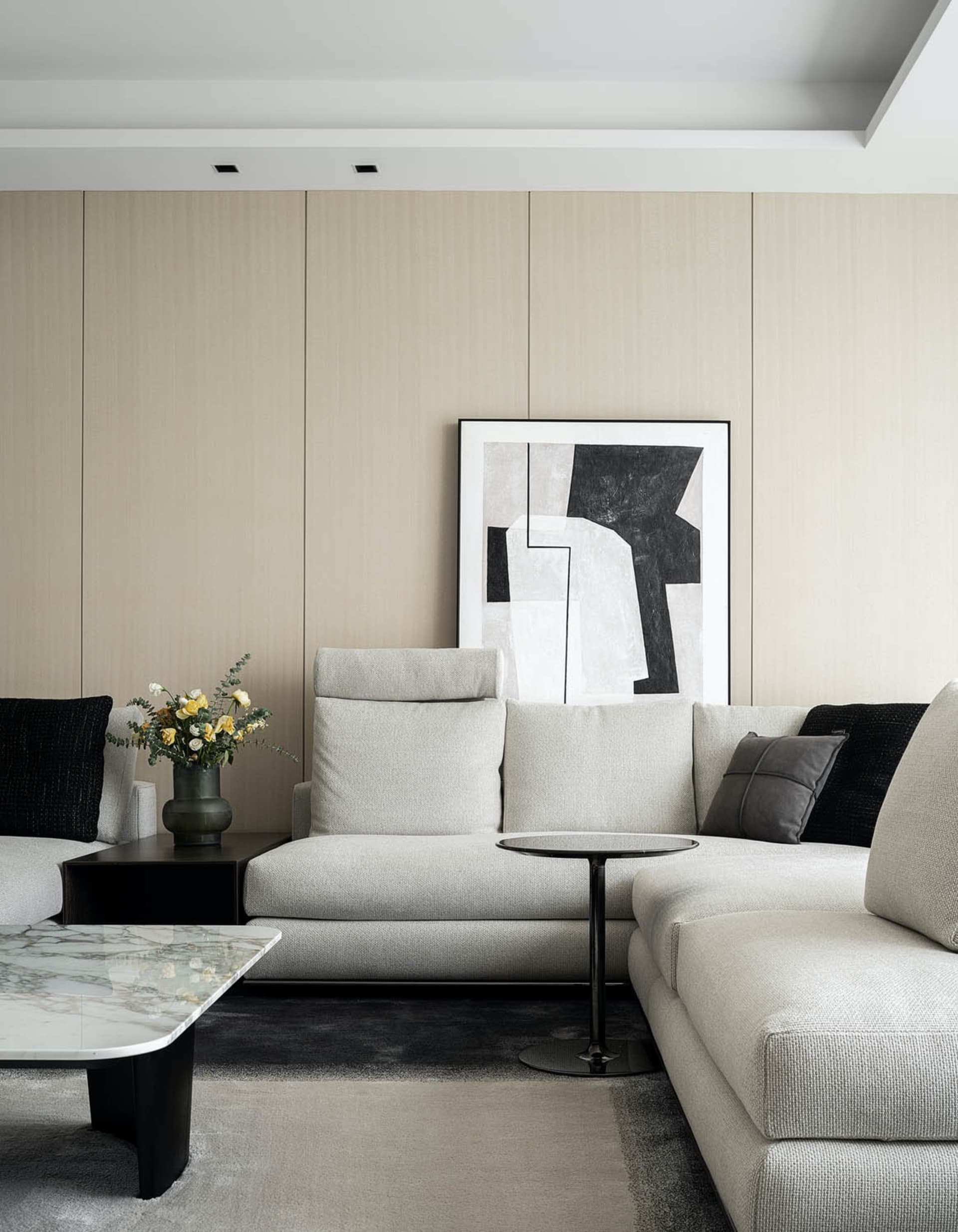 Contemporary, minimalist living room featuring a large, comfortable sofa upholstered in fabric and adorned with black and gra