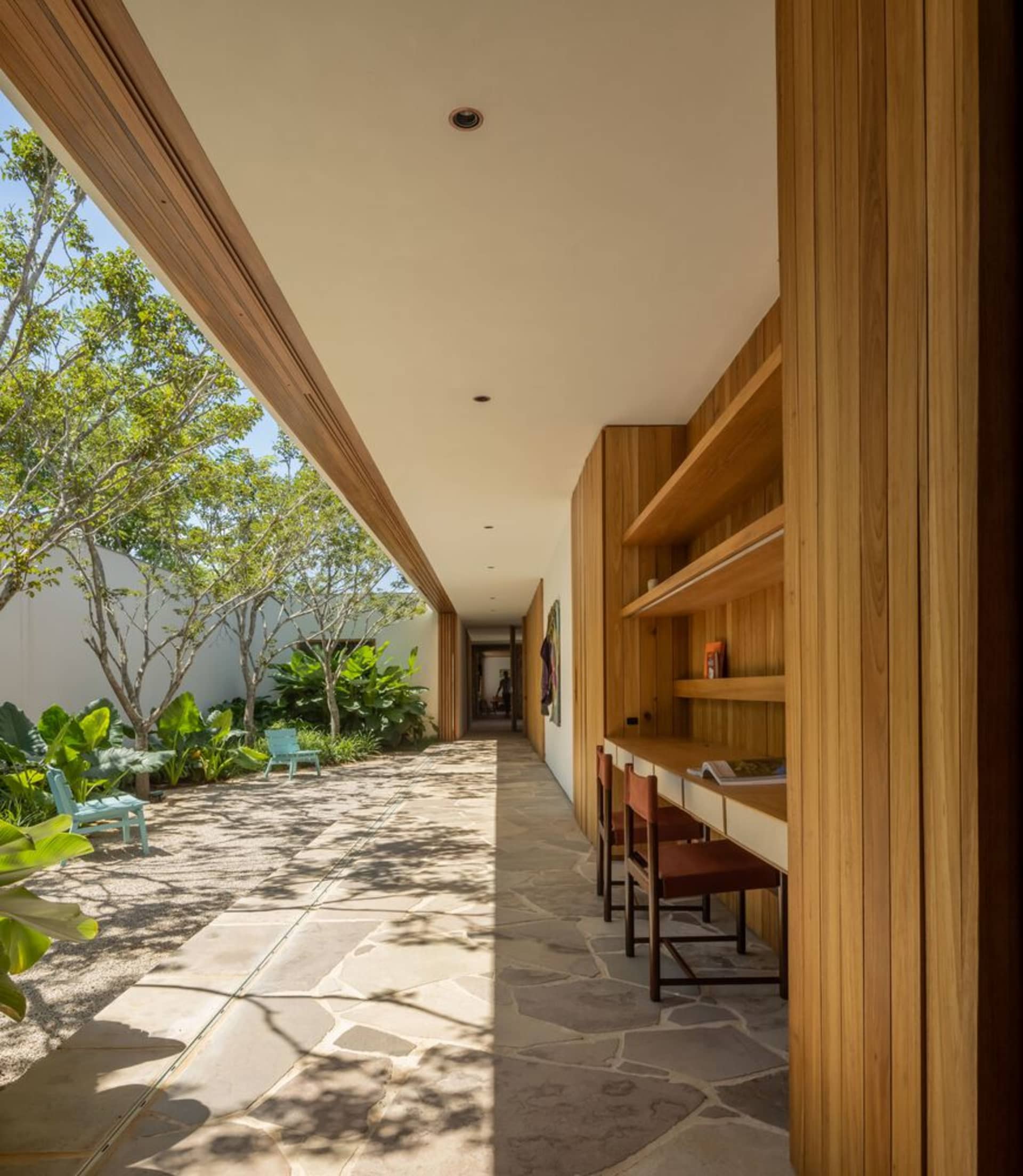 Modern house exterior featuring a wooden façade and outdoor seating area.