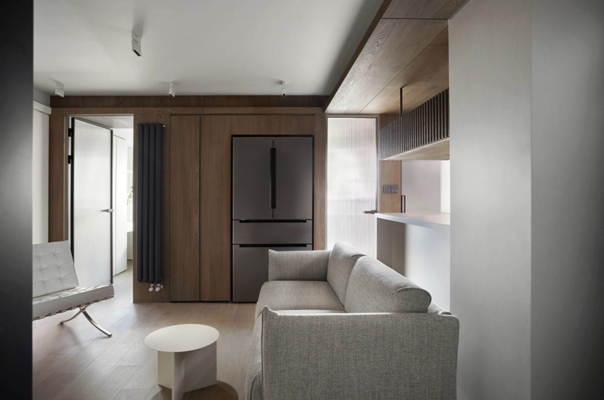 Modern minimalist living room featuring wooden furniture and a white sofa, showcasing a sleek, contemporary design.