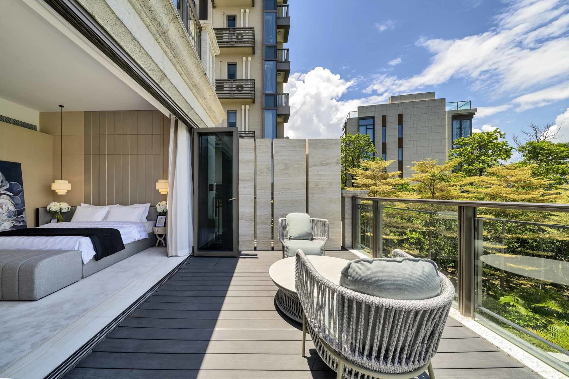 Modern residential balcony featuring metal elements, glass dividing walls, and wooden flooring.