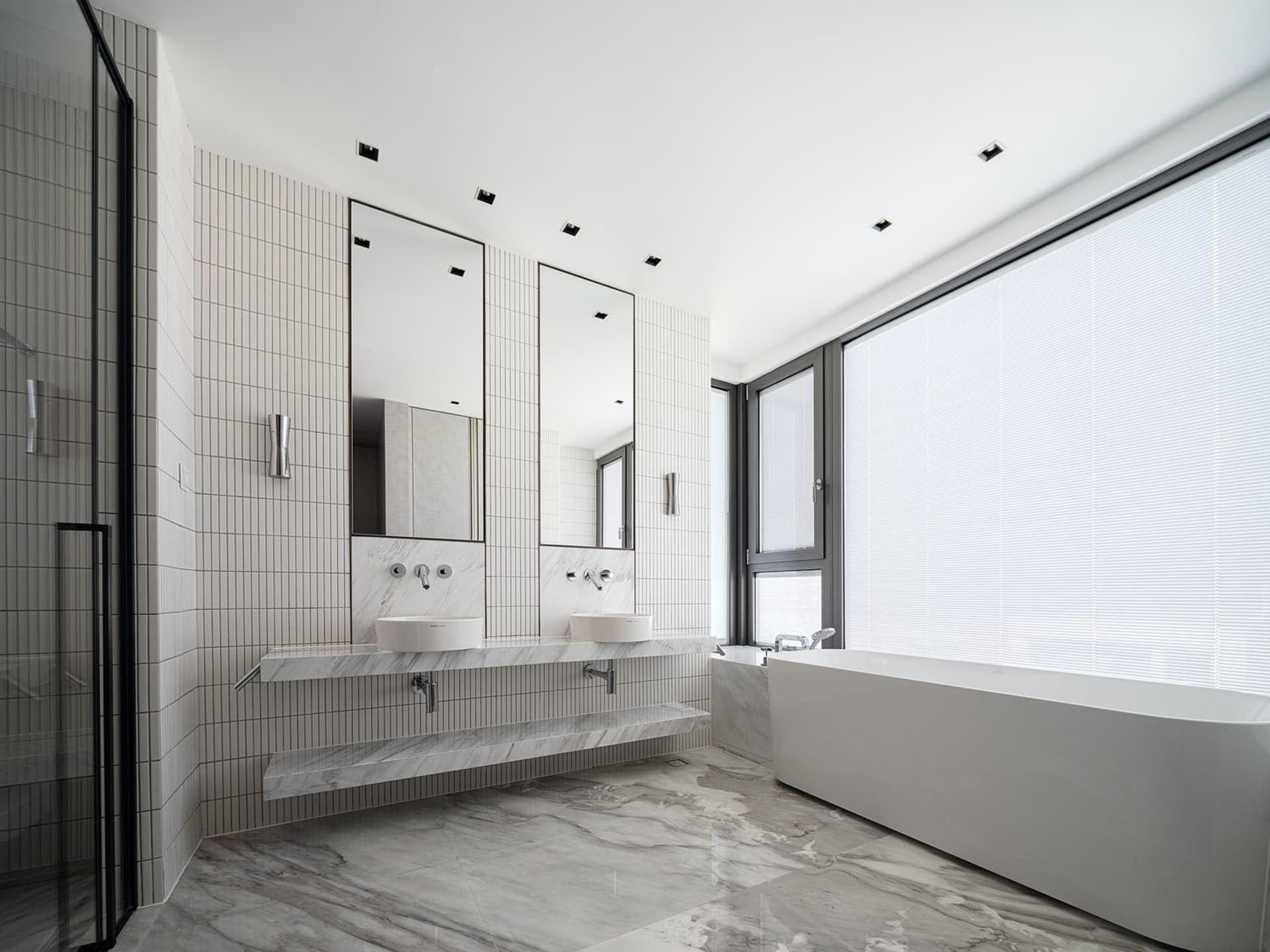 Modern minimalist bathroom with marble finishes and a large window.