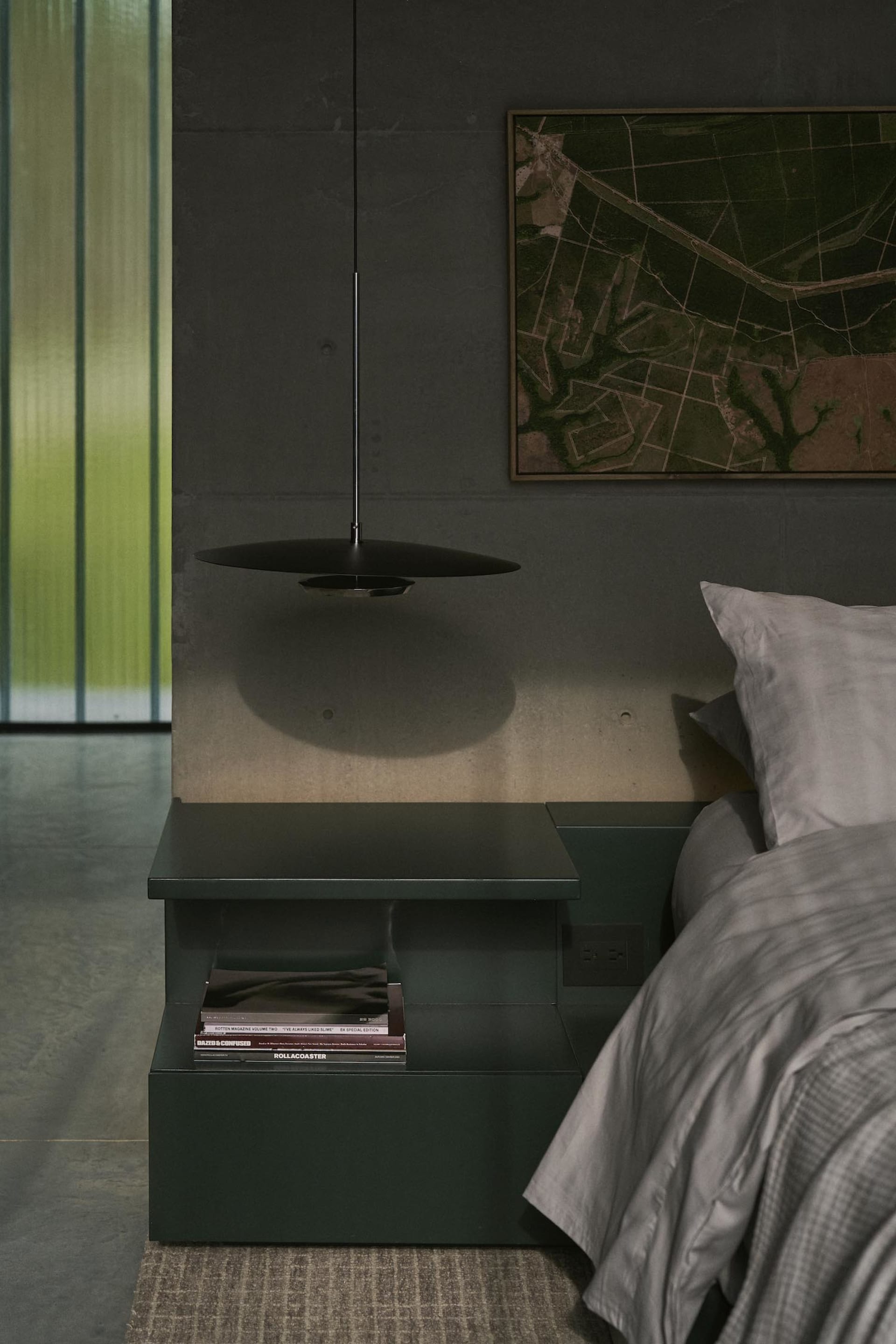 A modern bedroom featuring a metal shelf and a lamp hanging from the ceiling.