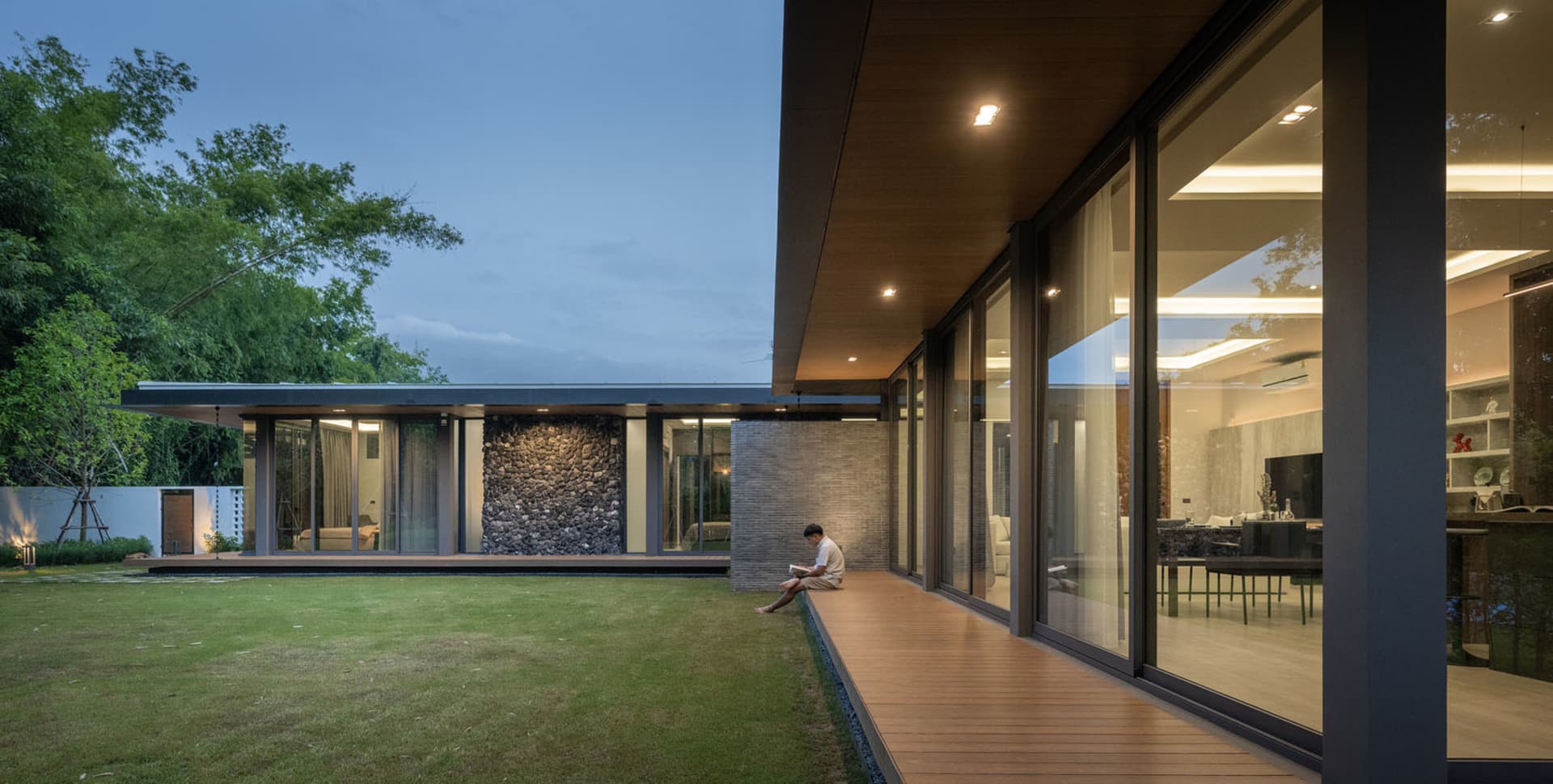 A modern house exterior featuring wood, glass, and stone materials.