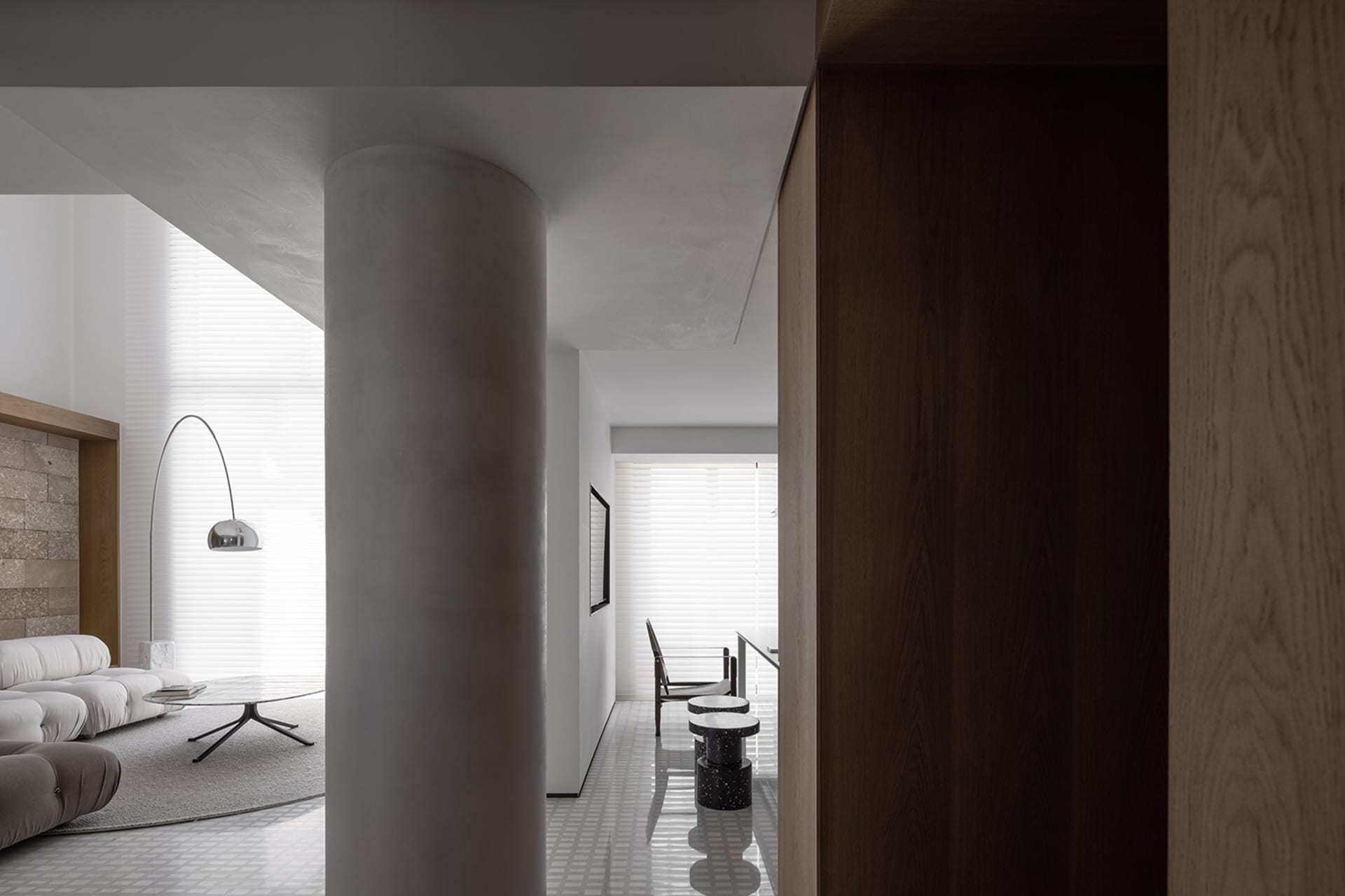 Contemporary living room with white marble finishes, sleek minimalist furniture, and a spacious design.