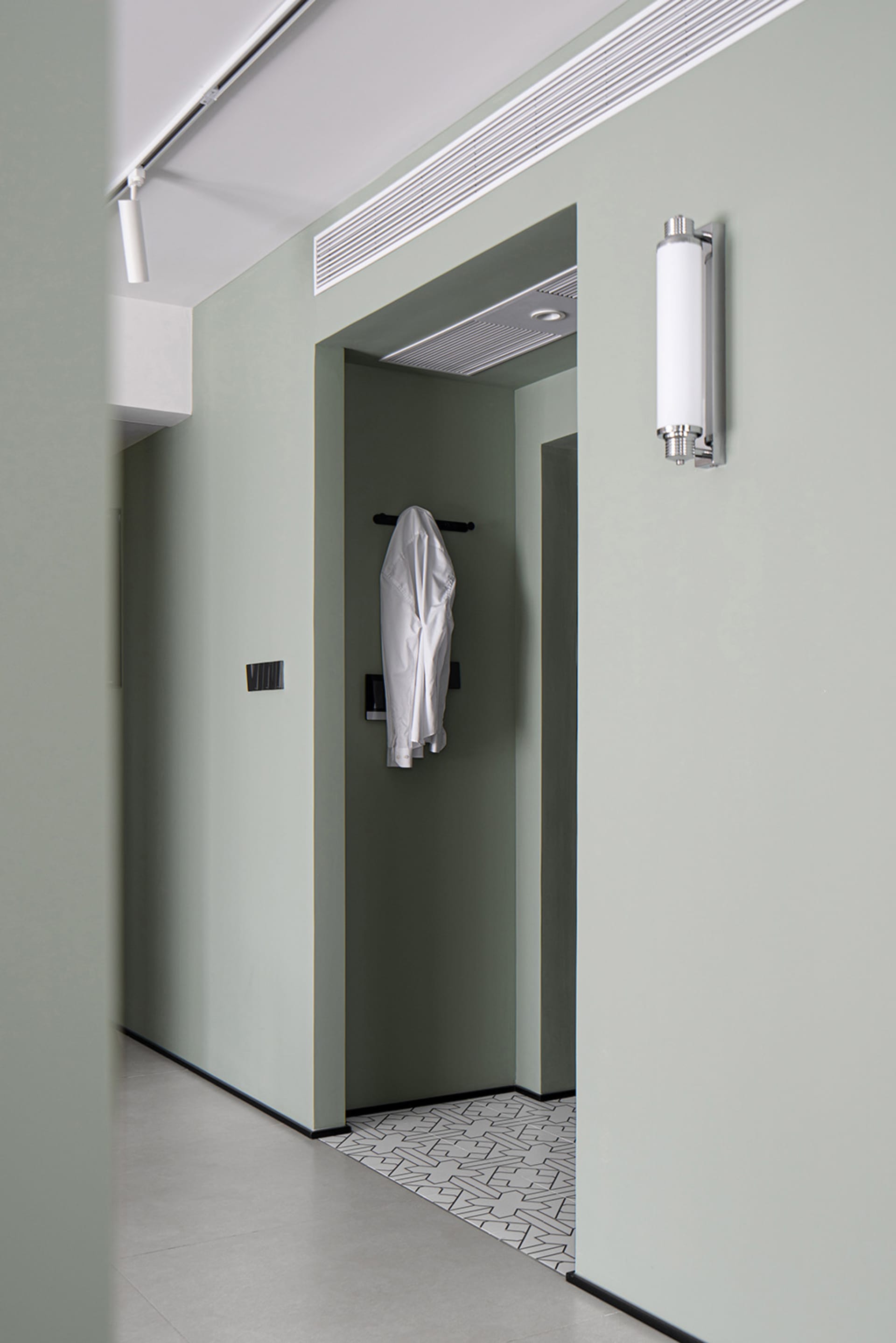 Modern interior design featuring a concrete finish wall and a coat hanger in the entryway.