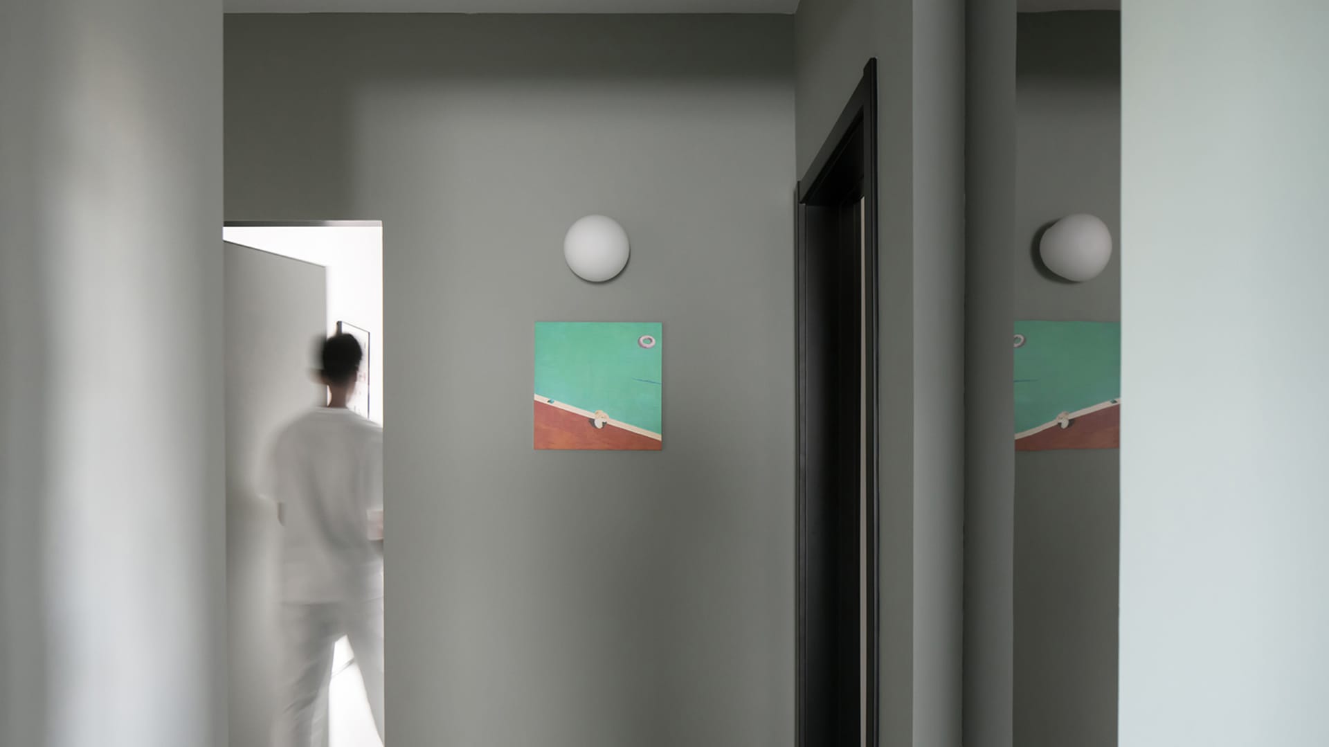 A minimalist entryway featuring abstract wall art with a green and red color scheme.