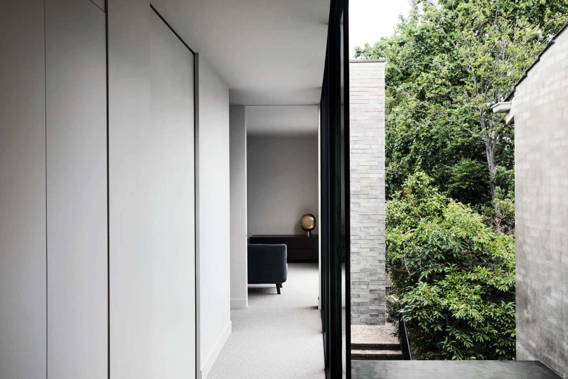 Interior design showcasing modern concrete walls and floor with a large window providing a view of greenery and natural light