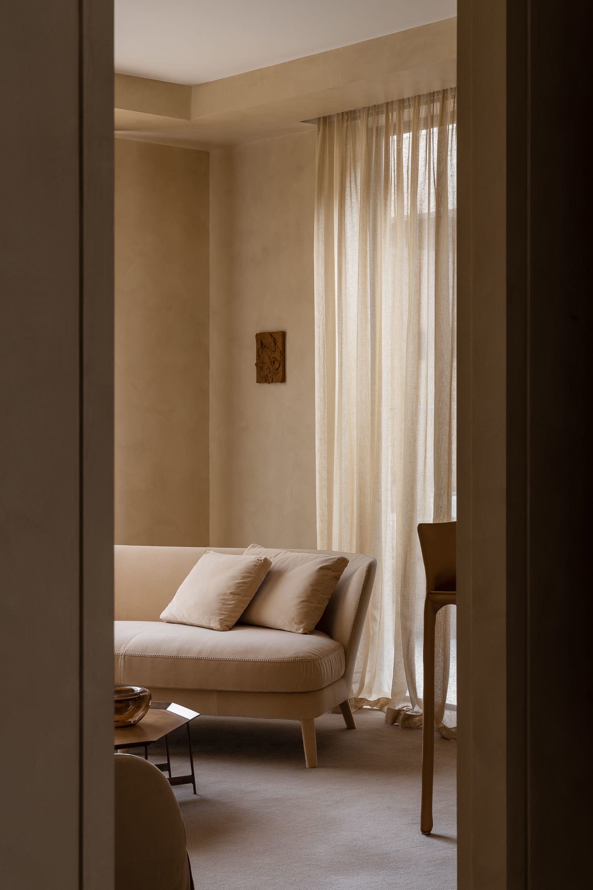 A cozy living room featuring neutral tones with fabric curtains for decor.