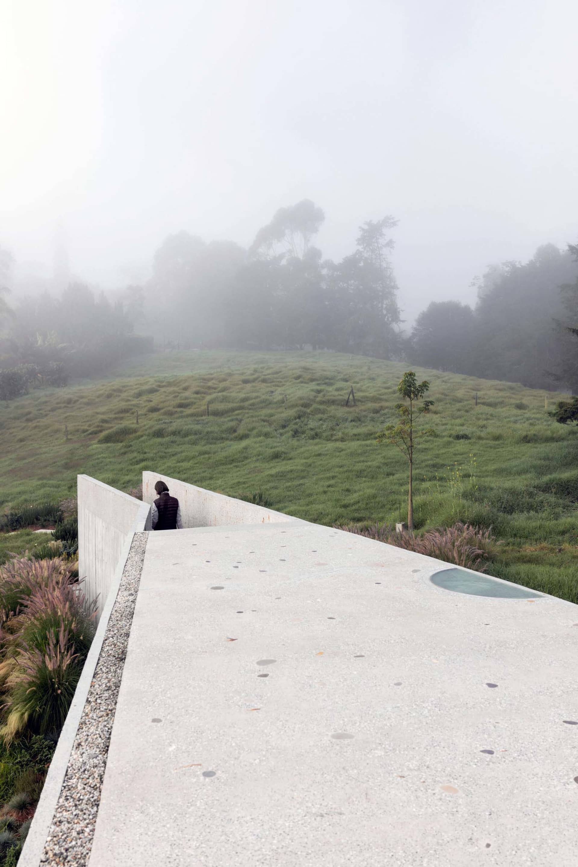 Modern concrete landscape with grassy hills and foggy background.