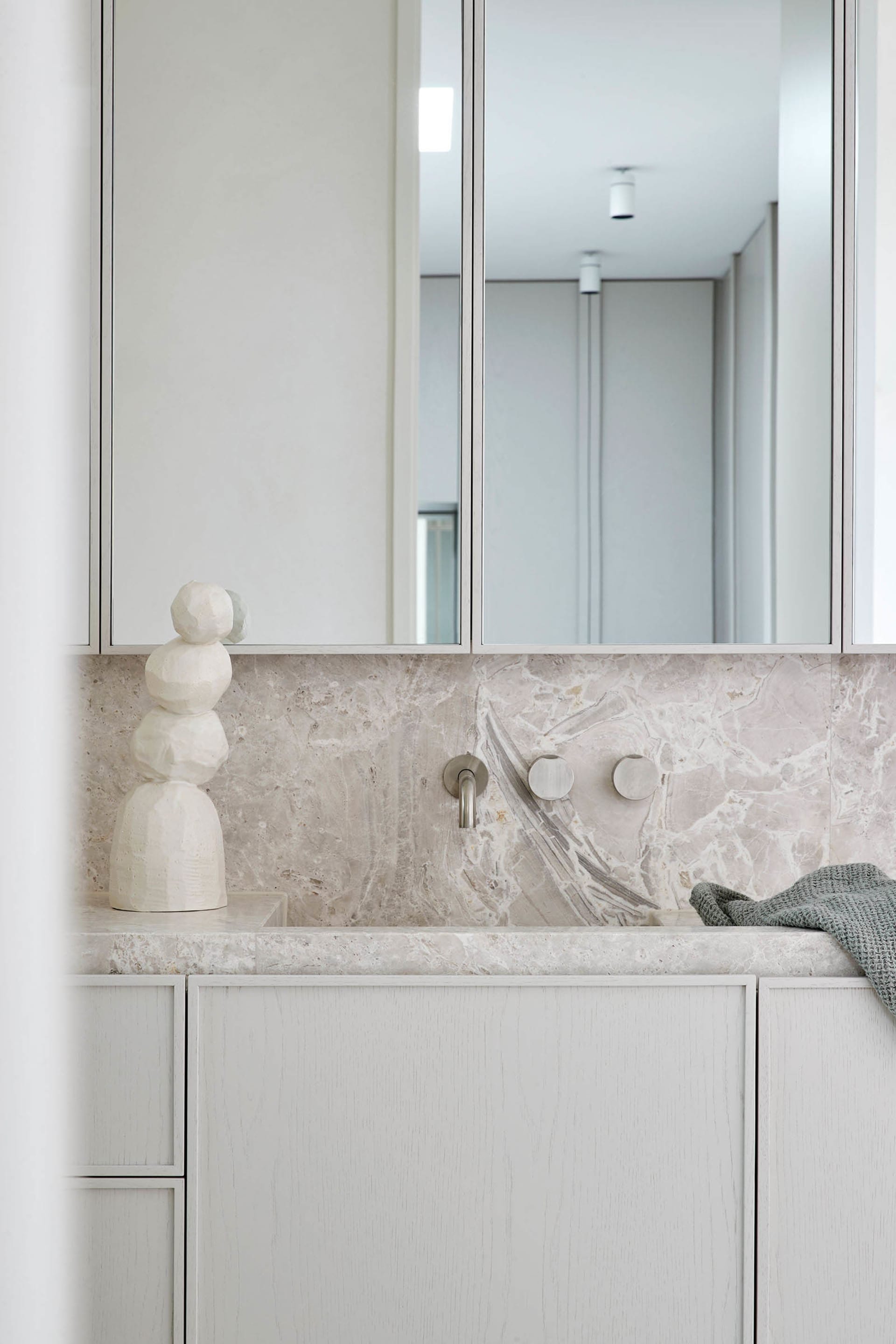 A modern, minimalist bathroom featuring marble countertops and minimalist design elements.