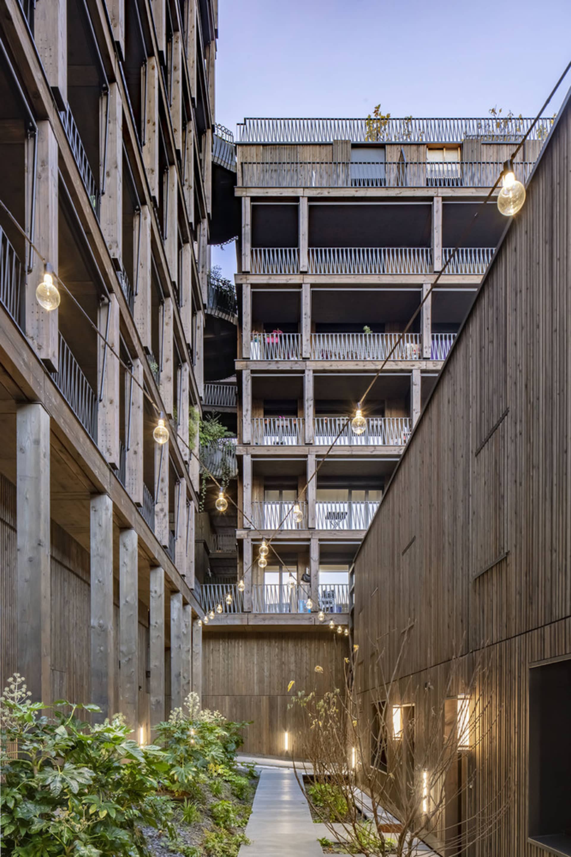 Modern residential architecture featuring wood exterior and balconies.