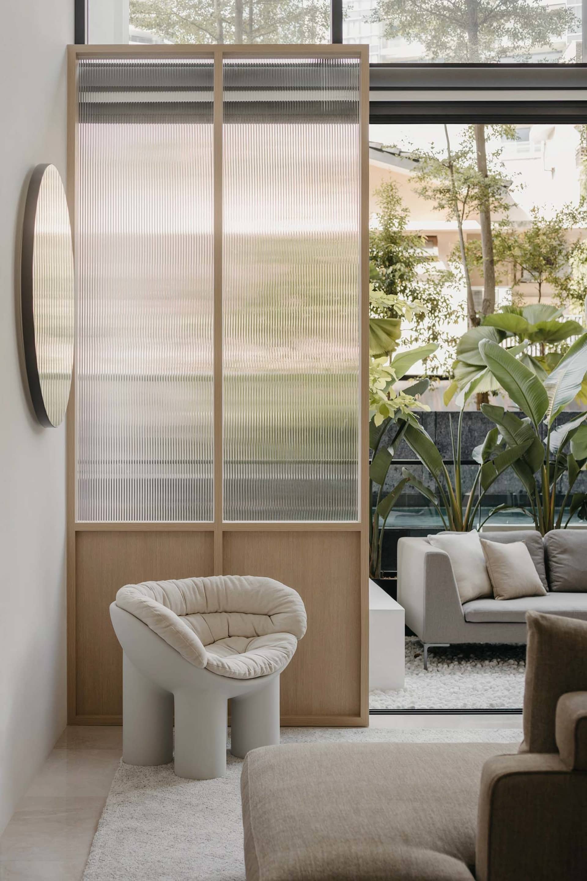 A minimalist living room featuring textured glass and wood elements.