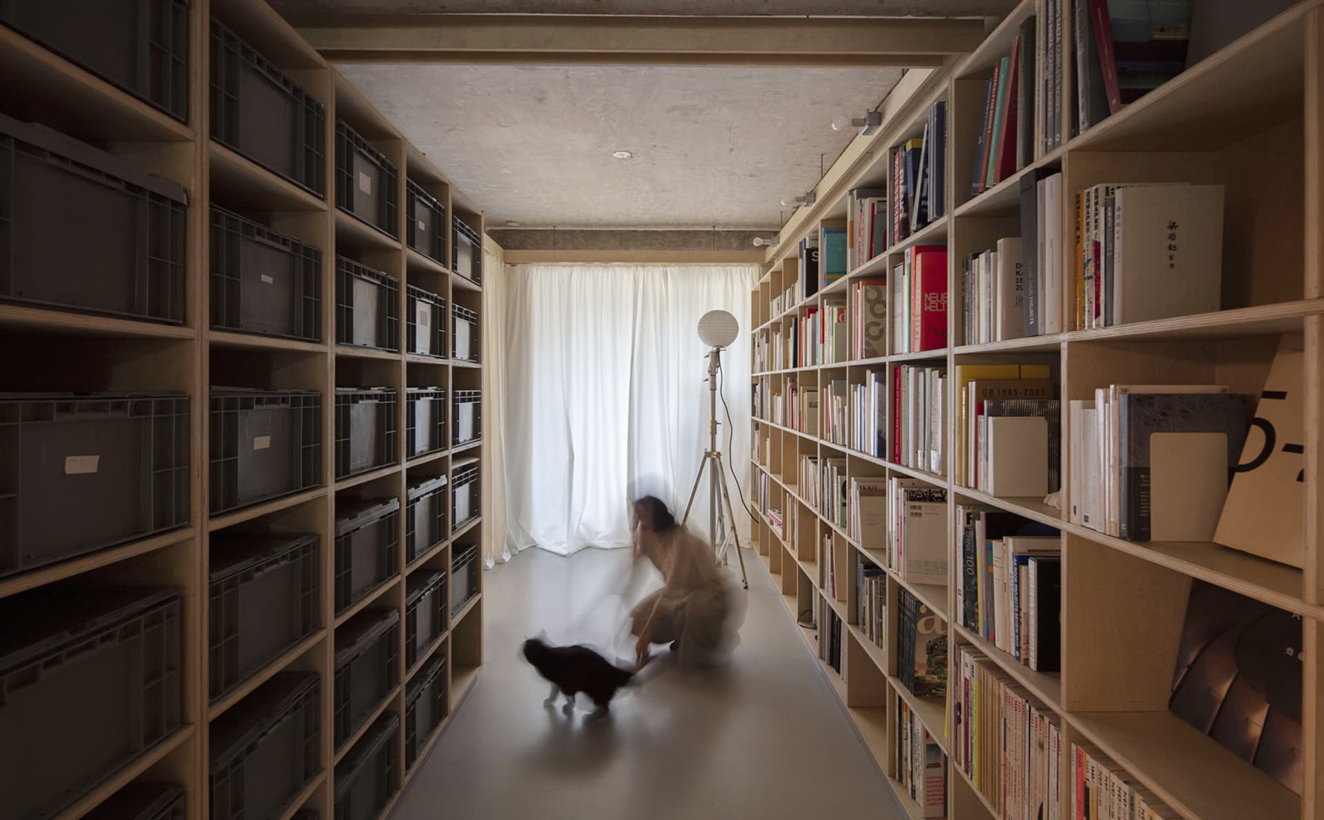 A modern library with wooden bookshelves and metal wire containers.