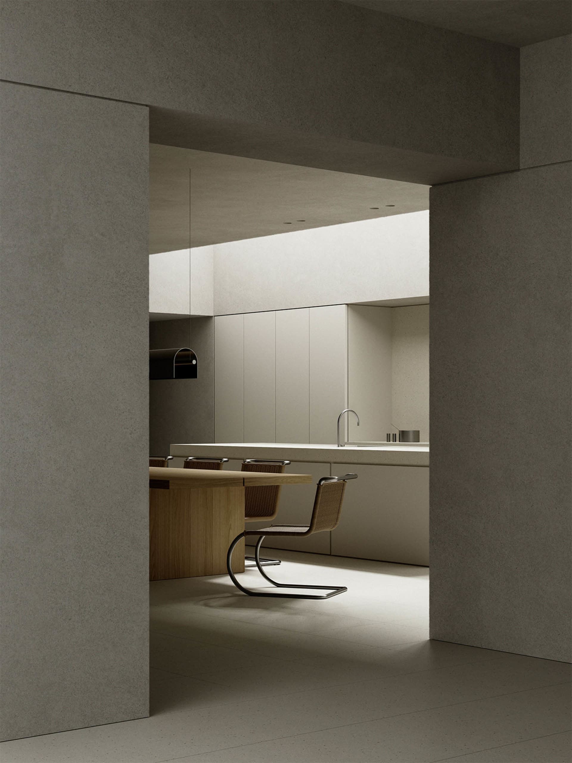Minimalist kitchen featuring concrete countertops and wooden dining table.