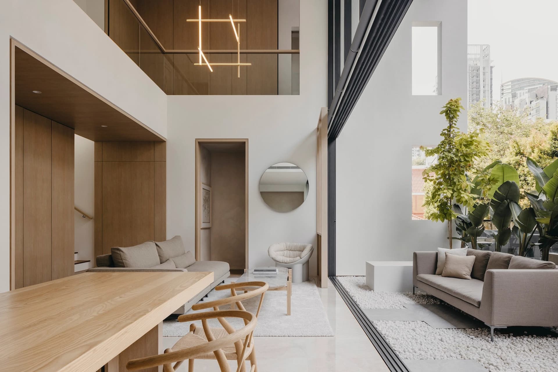A modern minimalist living room with wood accents, concrete flooring, and glass elements.