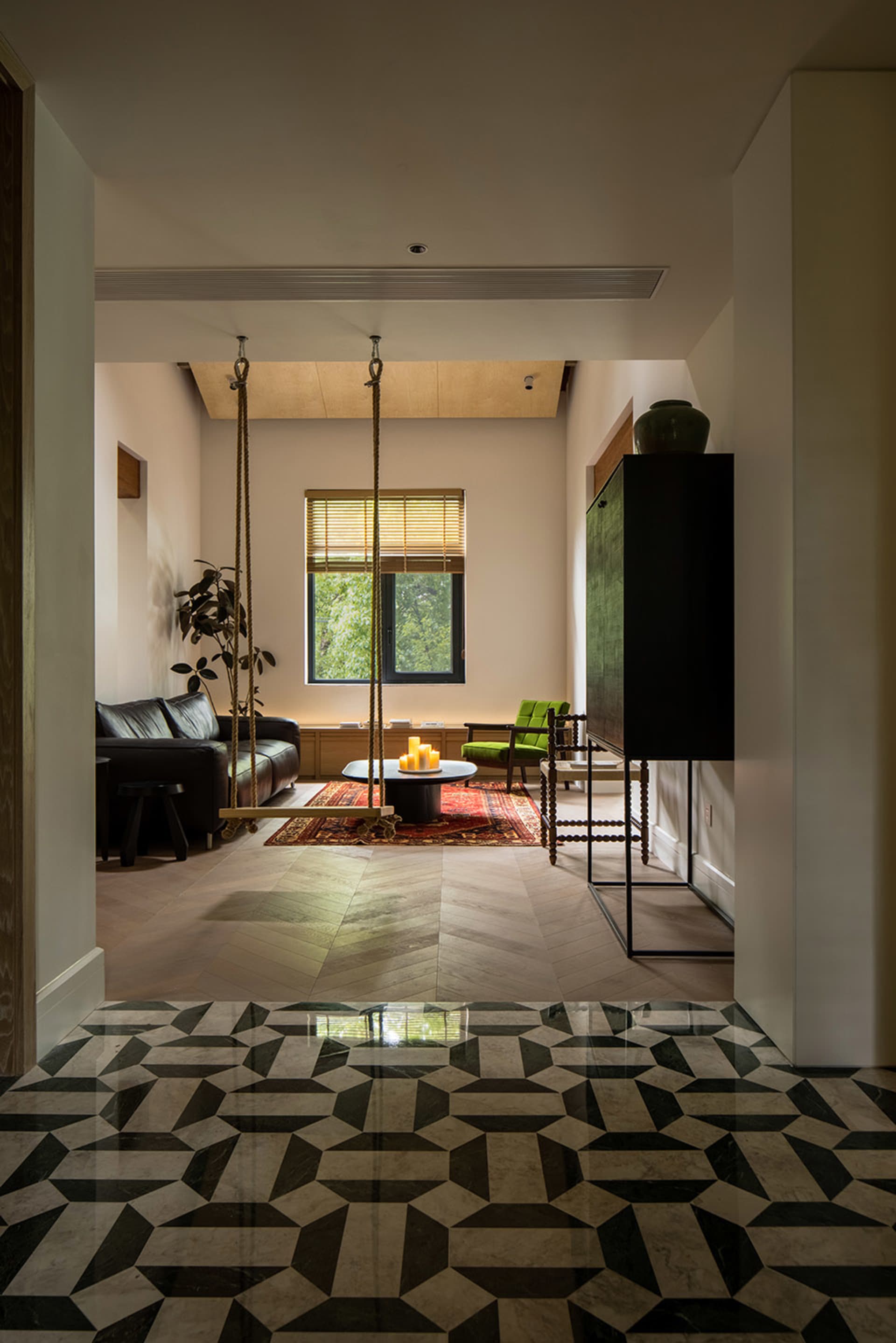 A modern living room with a floor pattern designed with black and white geometric shapes, featuring a sofa, coffee table, and