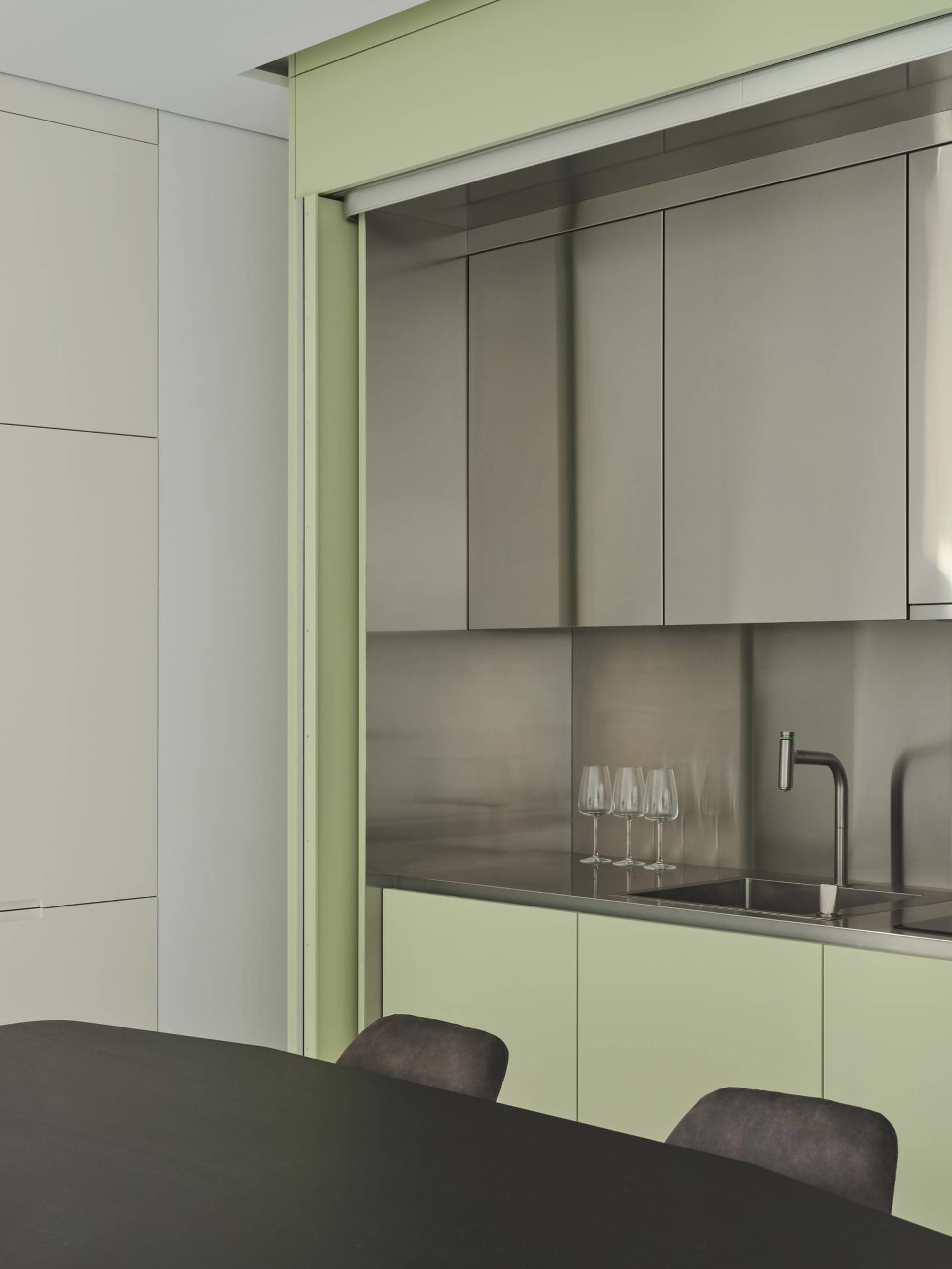 A minimalist kitchen with metallic cabinets and a sleek, modern design.