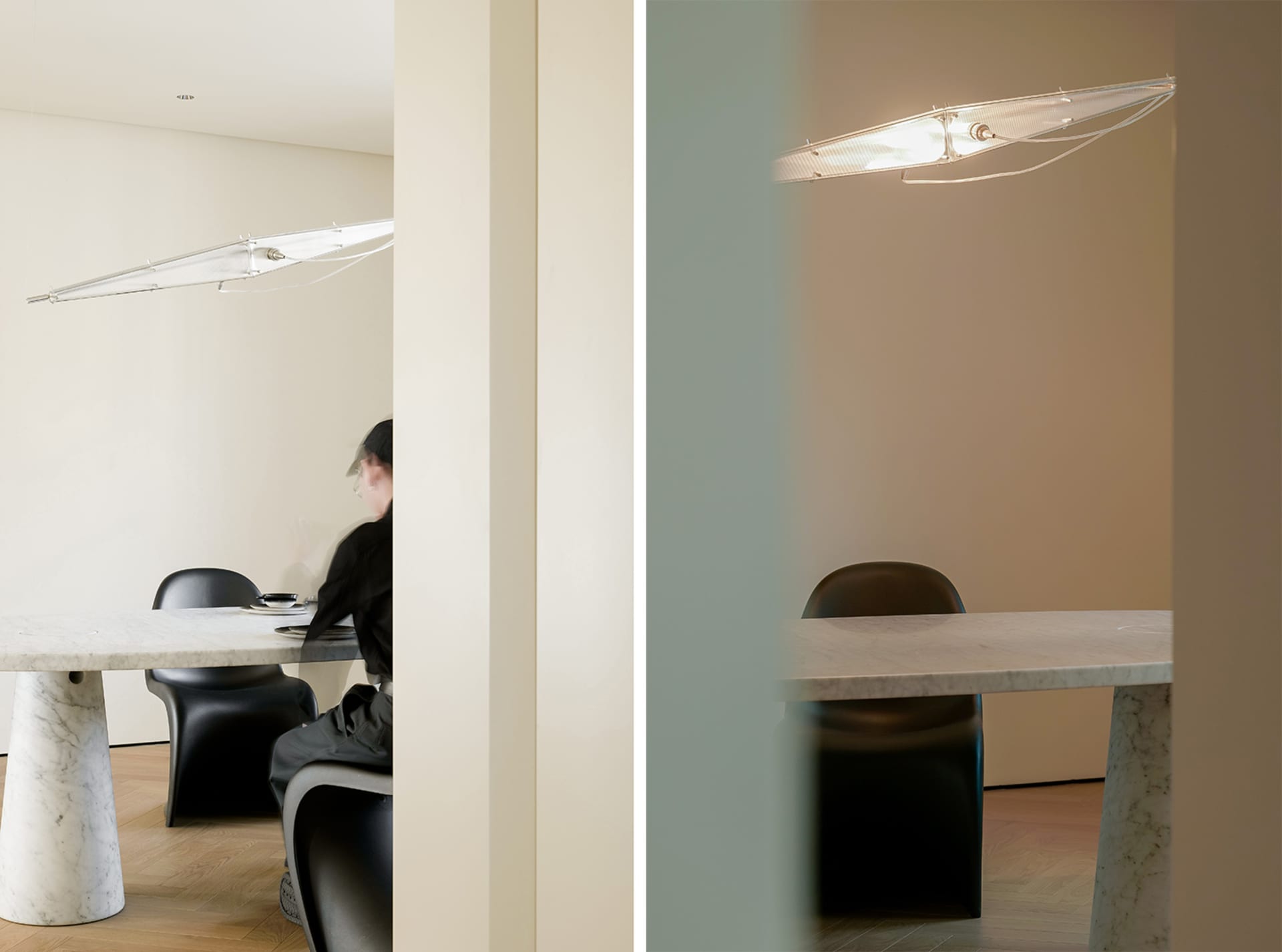 A minimalist dining room featuring a marble table and black chairs under a contemporary light fixture.