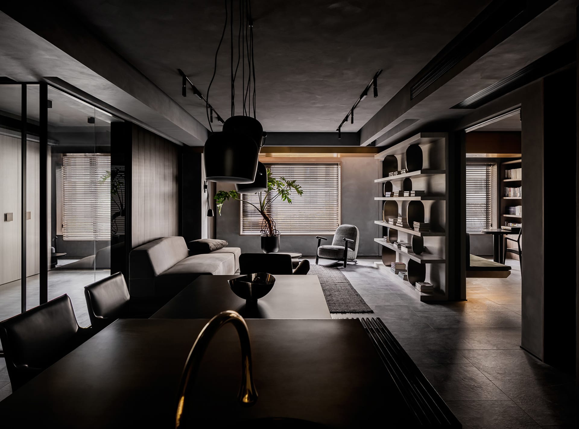 A modern living room with concrete walls, concrete chairs, and a concrete floor.