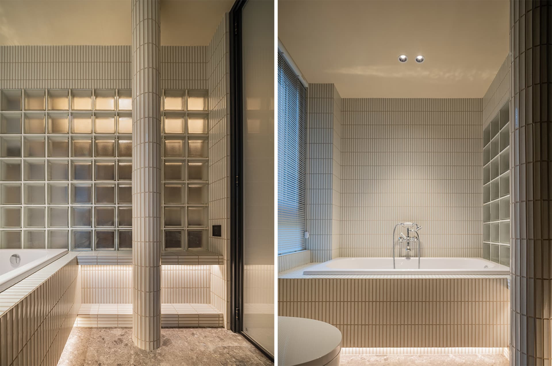 Modern bathroom with white ceramic tiles, glass block wall, and freestanding bathtub.