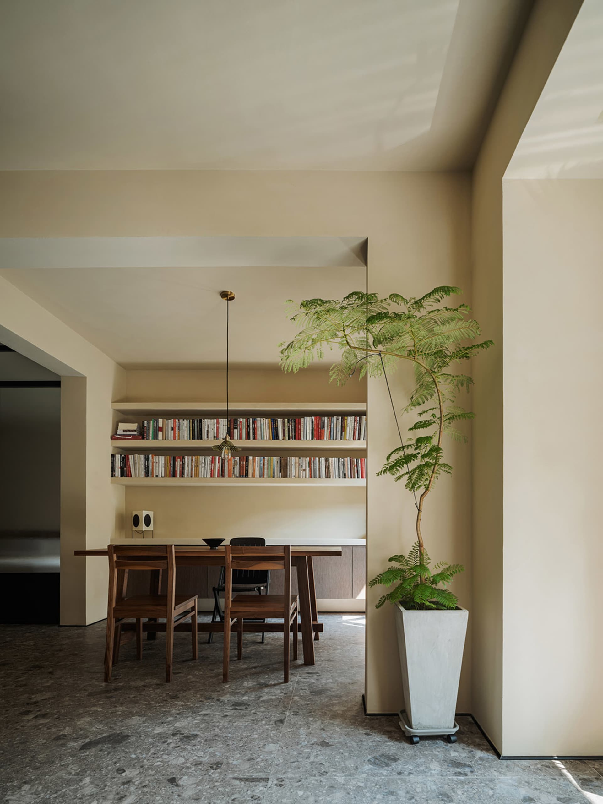 A modern dining room featuring wooden furniture and concrete accents.