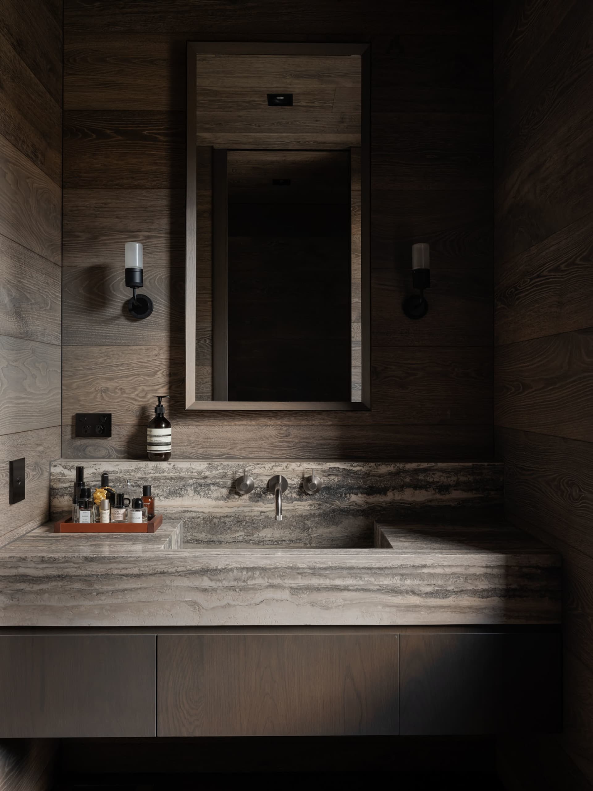 Modern industrial bathroom featuring a stone vanity counter and metal faucet fixtures.