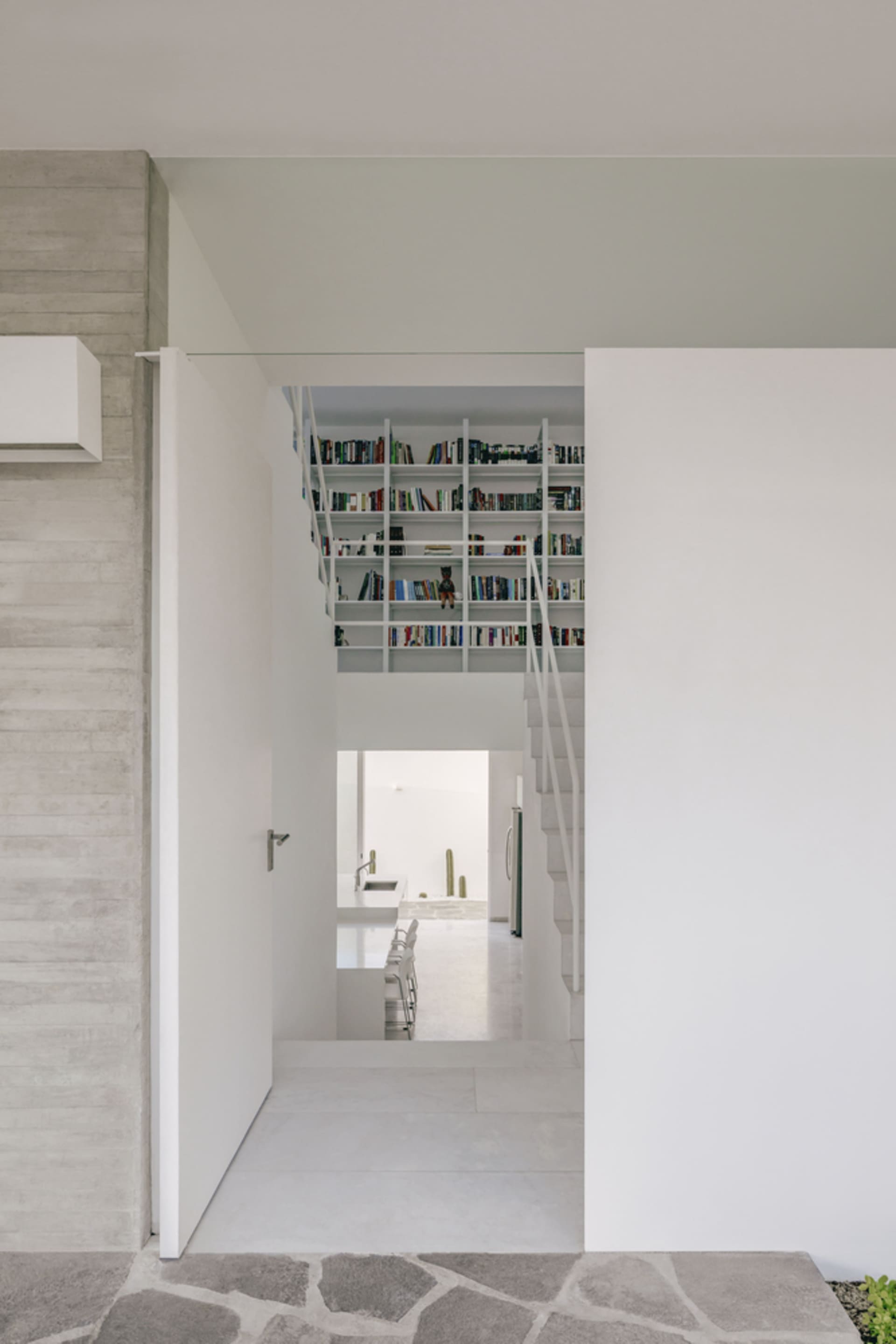 A modern interior space featuring concrete shelving filled with books.