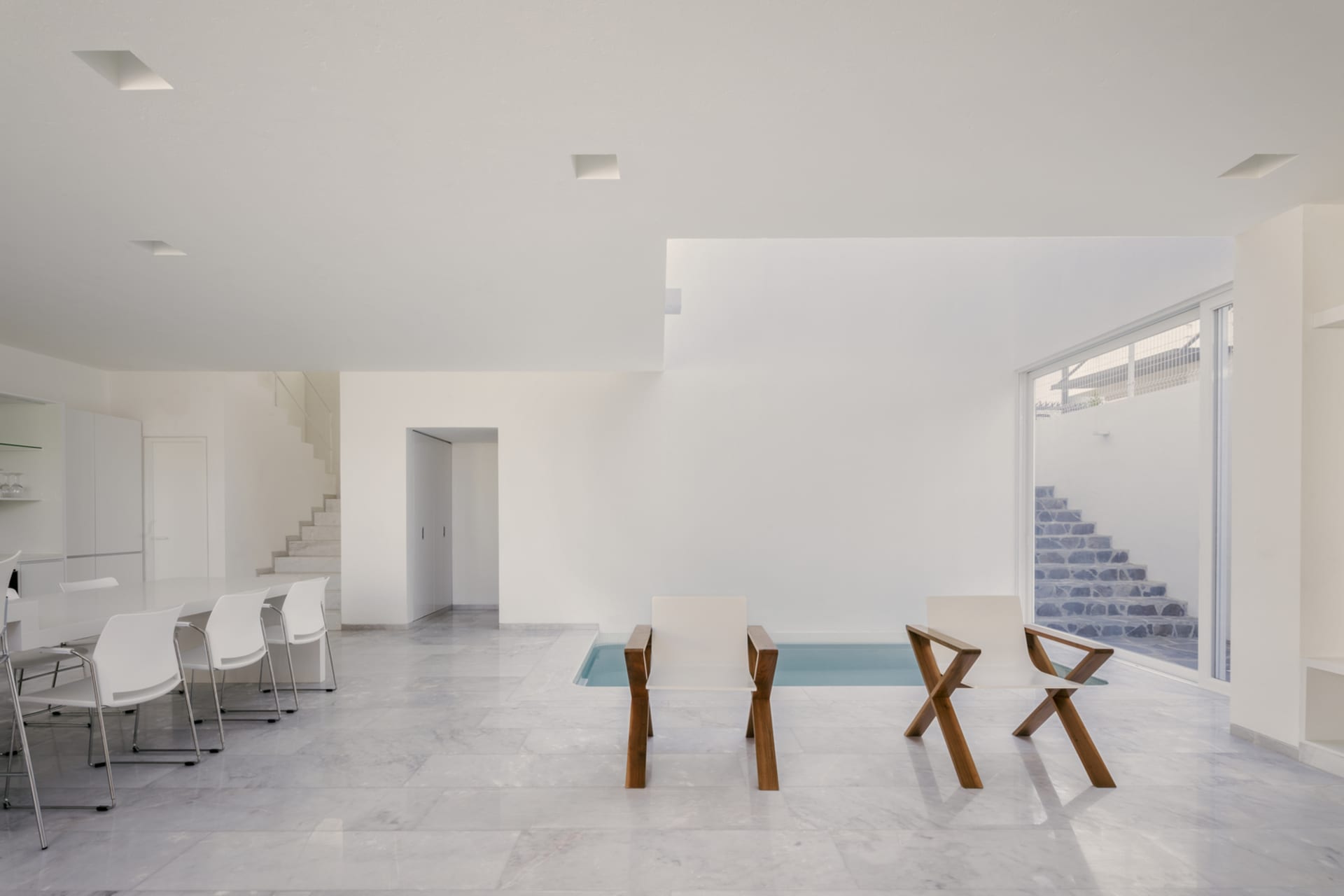 Minimalist living room with marble floor and pool area