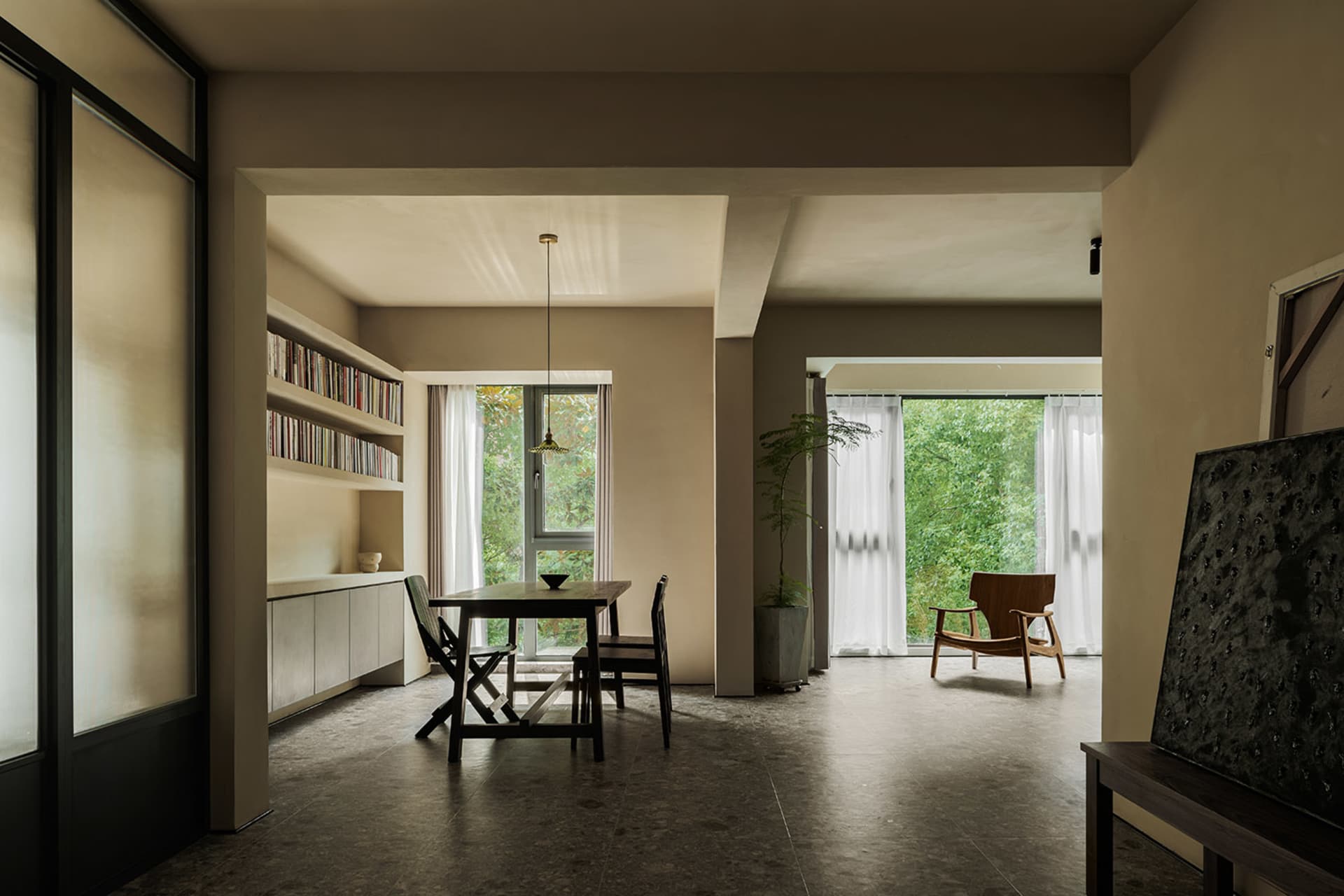 Modern industrial residential interior with minimalist design, concrete walls, and large windows.