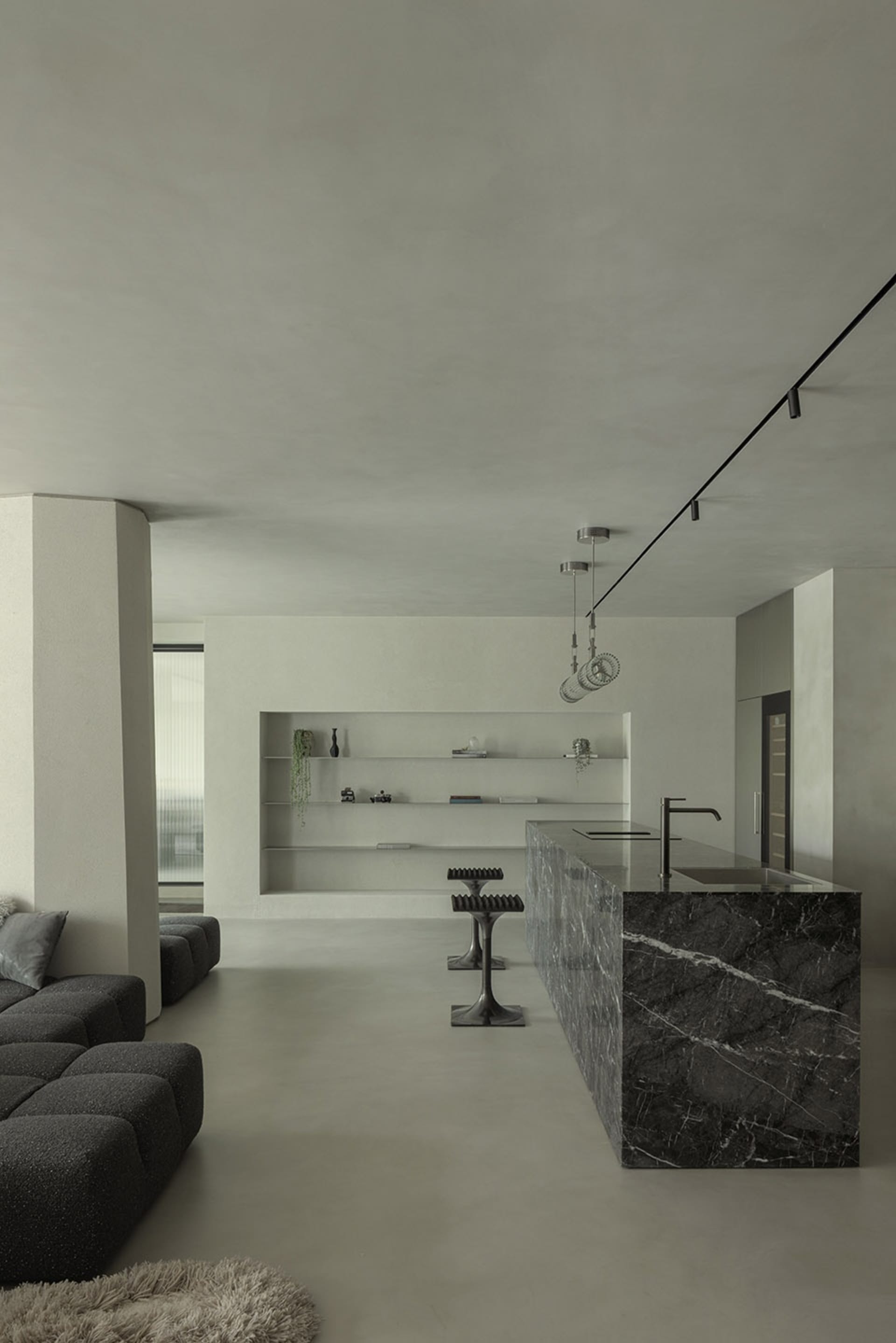 A minimalist kitchen with a marble countertop and island.