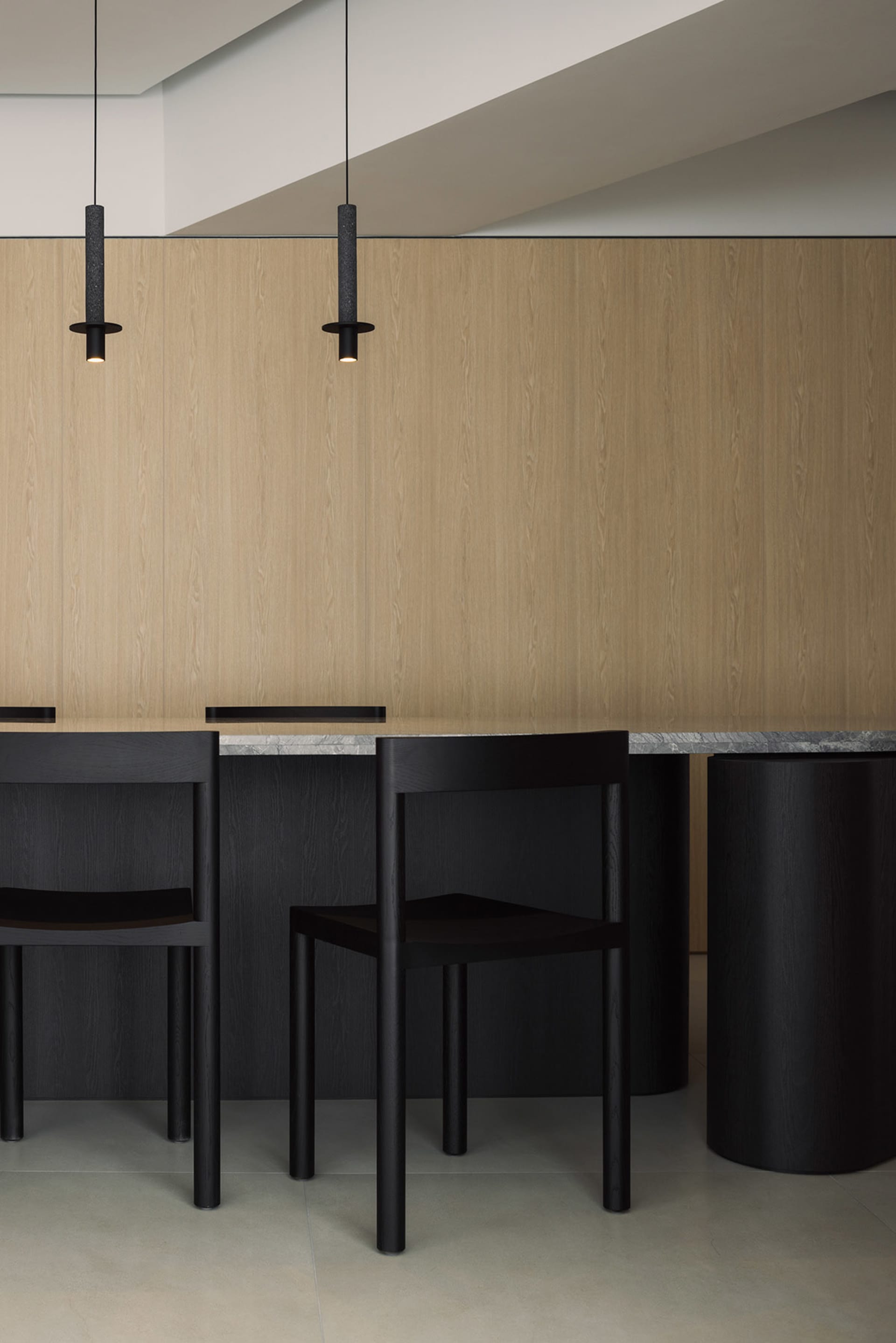 A modern kitchen with wooden cabinets and a marble countertop and floor.