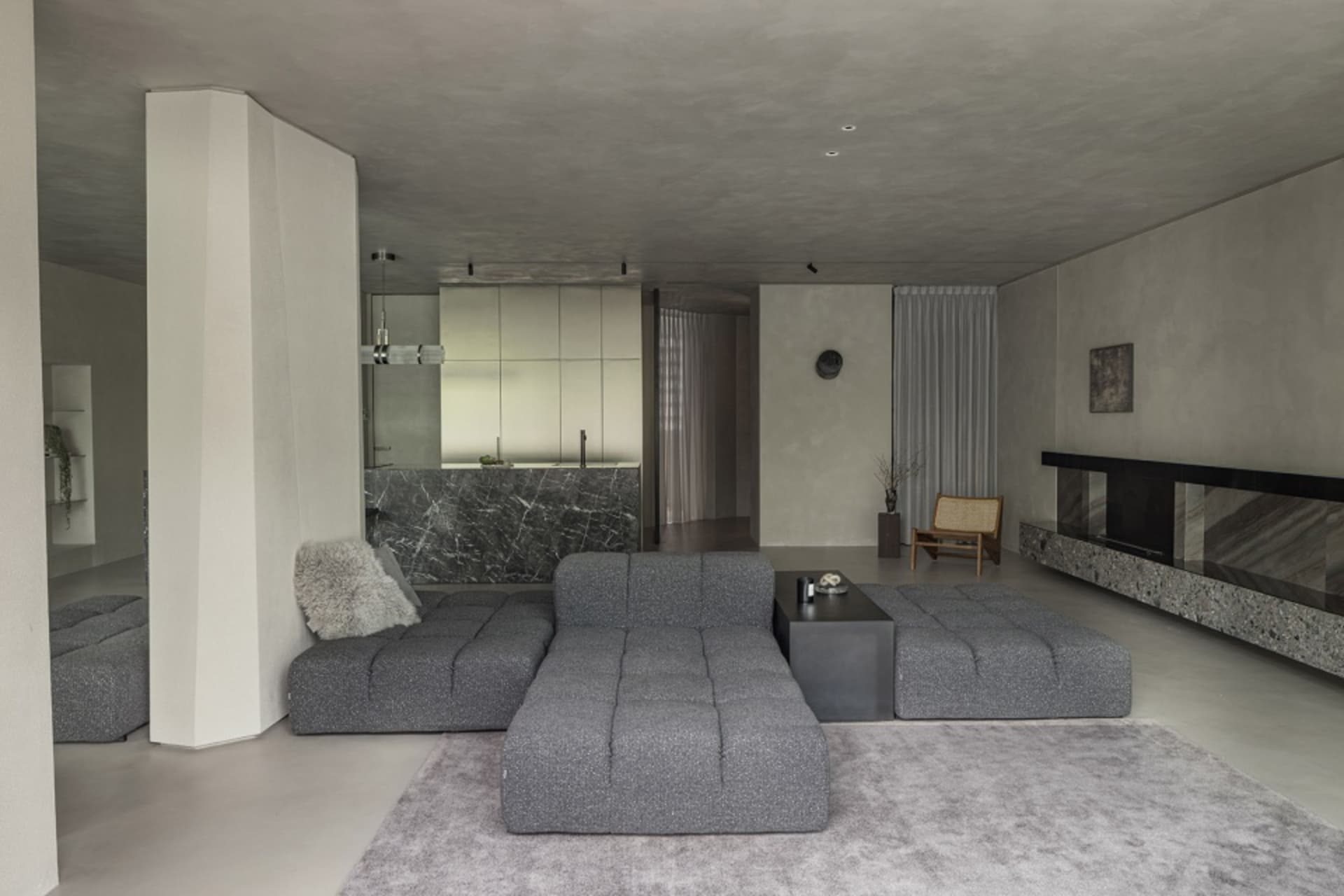 A modern living room with concrete and marble materials