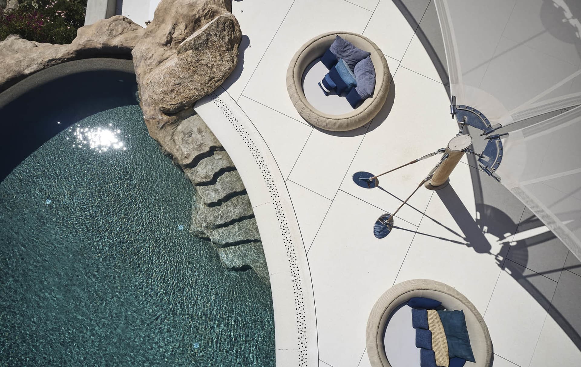 A modern residential patio featuring a concrete surface, glass elements, and blue decoration.