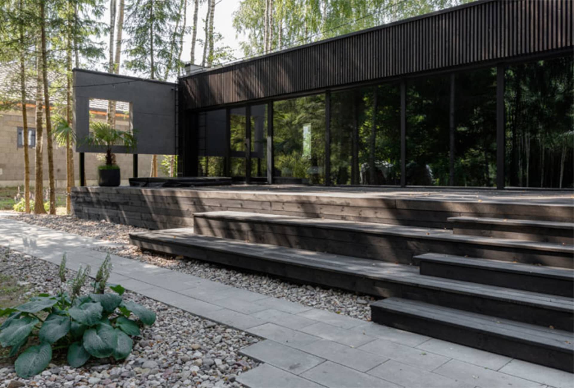 A modern residential exterior featuring a combination of wood and glass materials.