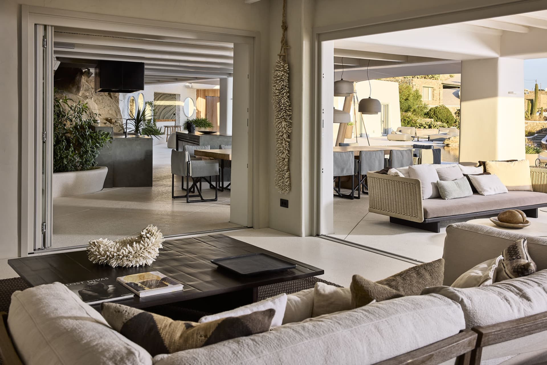 A modern residential room featuring neutral textiles and concrete flooring, with a focus on comfort and minimalist design.