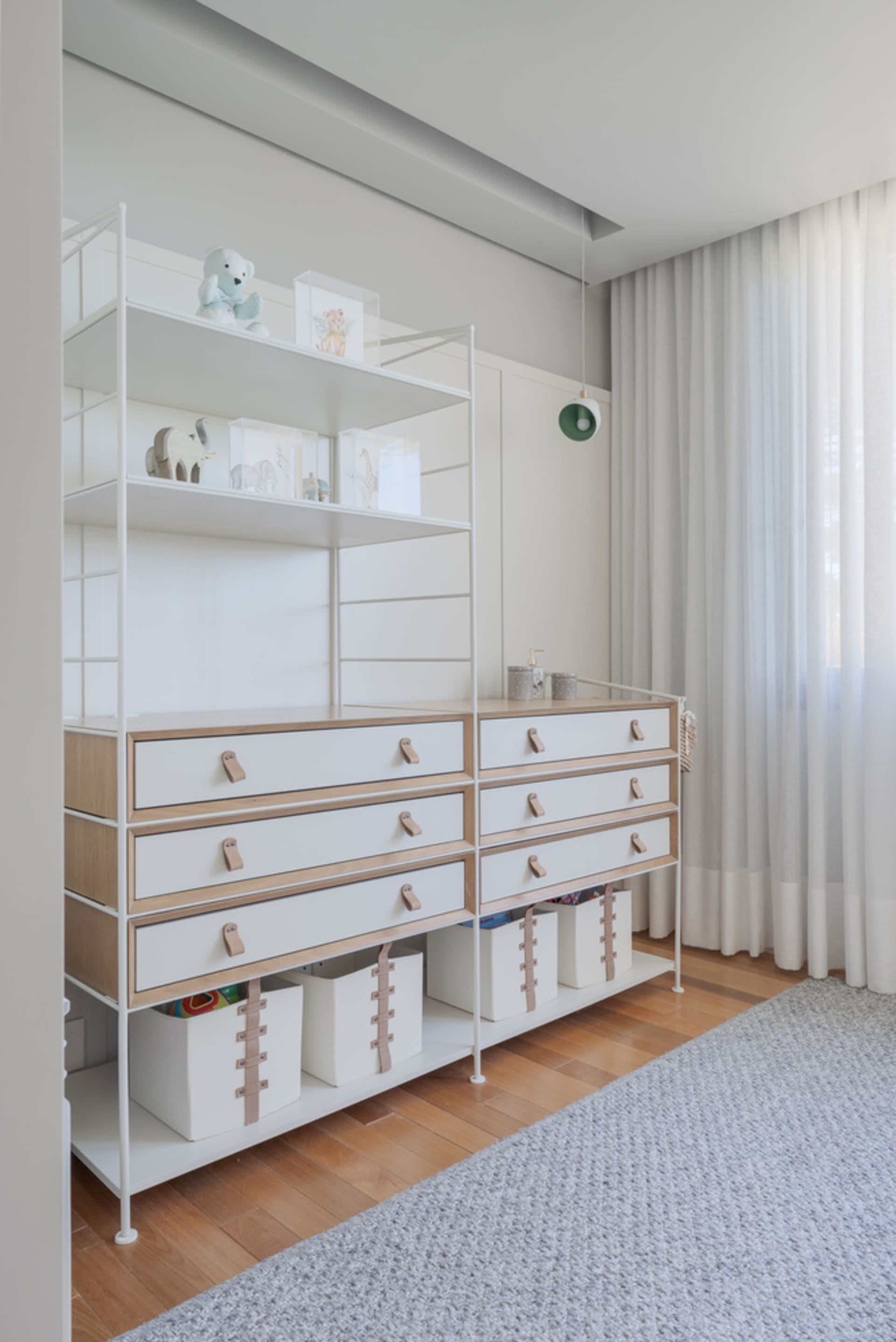 Minimalist bedroom with white furniture, wooden floors, and a gray rug.