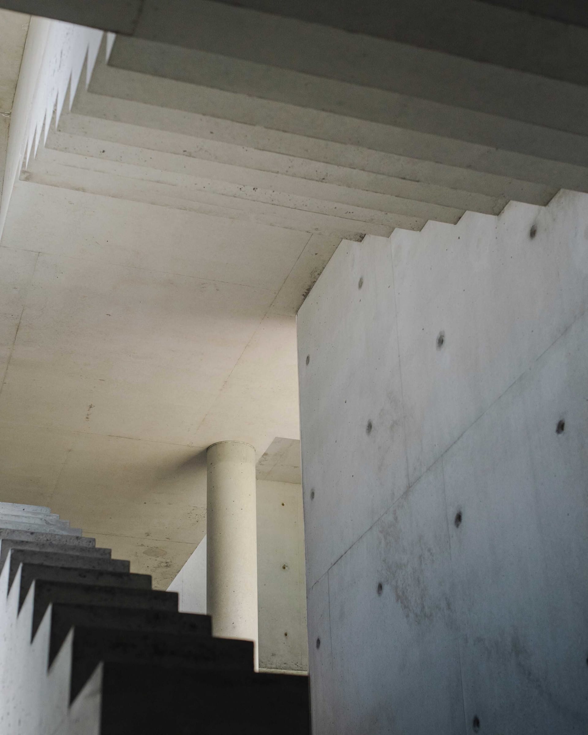 A modern industrial interior space with concrete walls and ceiling.