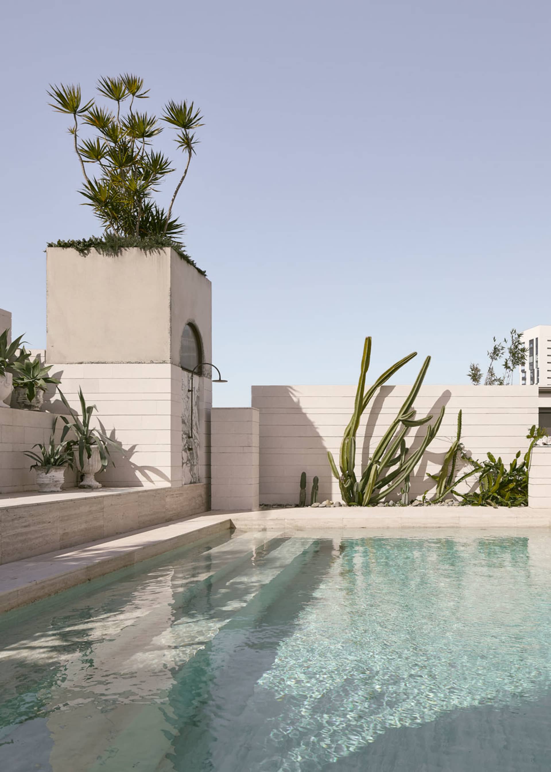 Outdoor space with concrete structures, plants, and a swimming pool