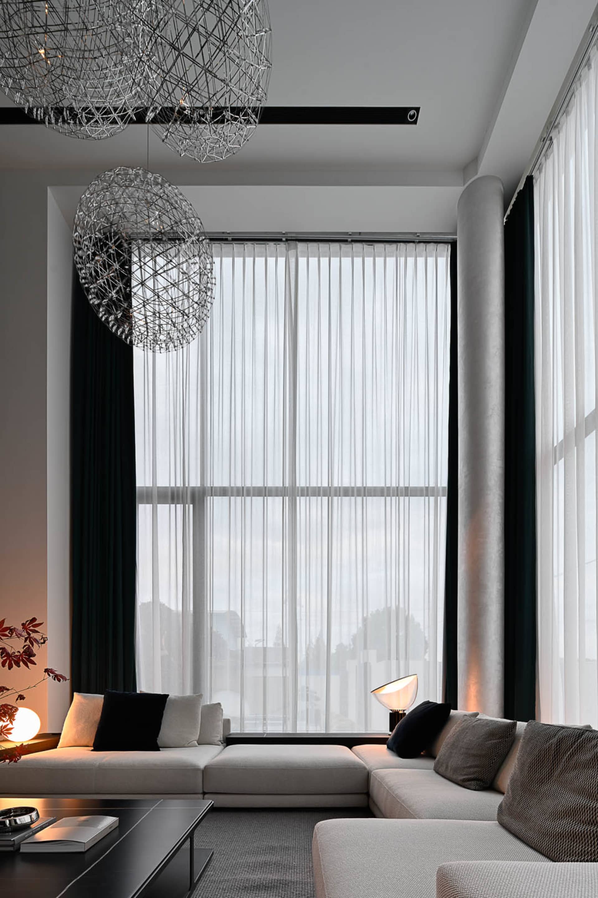 Modern living room featuring textured curtains, minimalist furniture, and contemporary lighting.