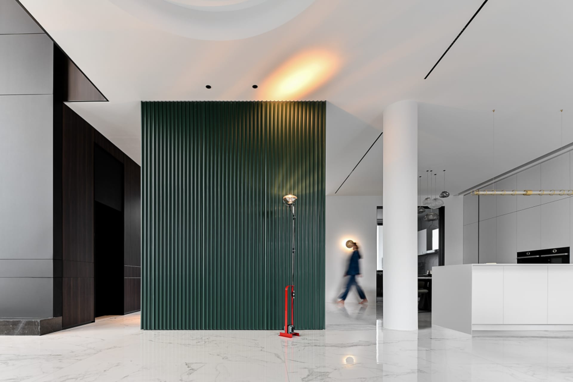 A modern residential hallway with a green metal-clad wall panel and a reflective white marble floor.